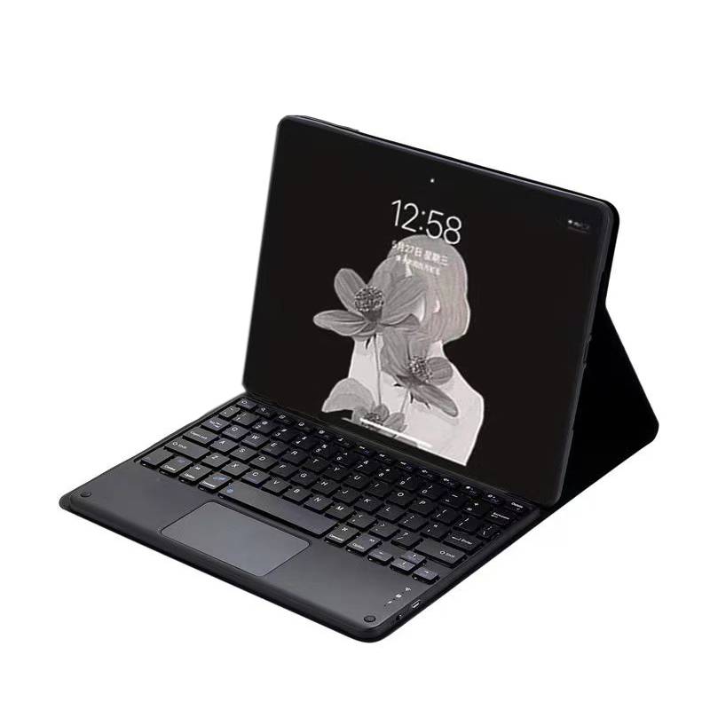 Ein schwarzes Tablet in einer Tastaturhülle, aufgeklappt wie ein kleiner Laptop, mit dem Bildschirm, der eine Blumentapete und die Uhrzeit 12:58 anzeigt.