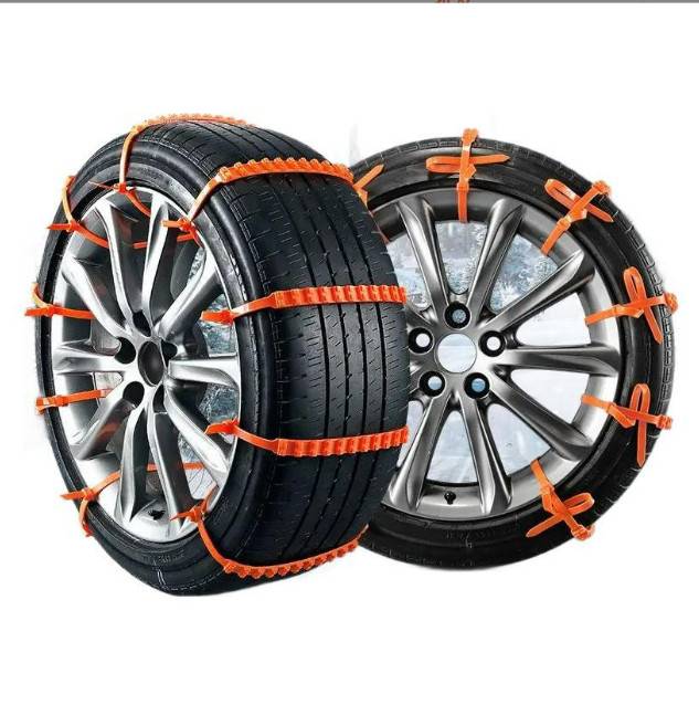 Zwei Autoreifen mit orangefarbenen Schneeketten umwickelt, auf Leichtmetallfelgen gegen einen weißen Hintergrund.