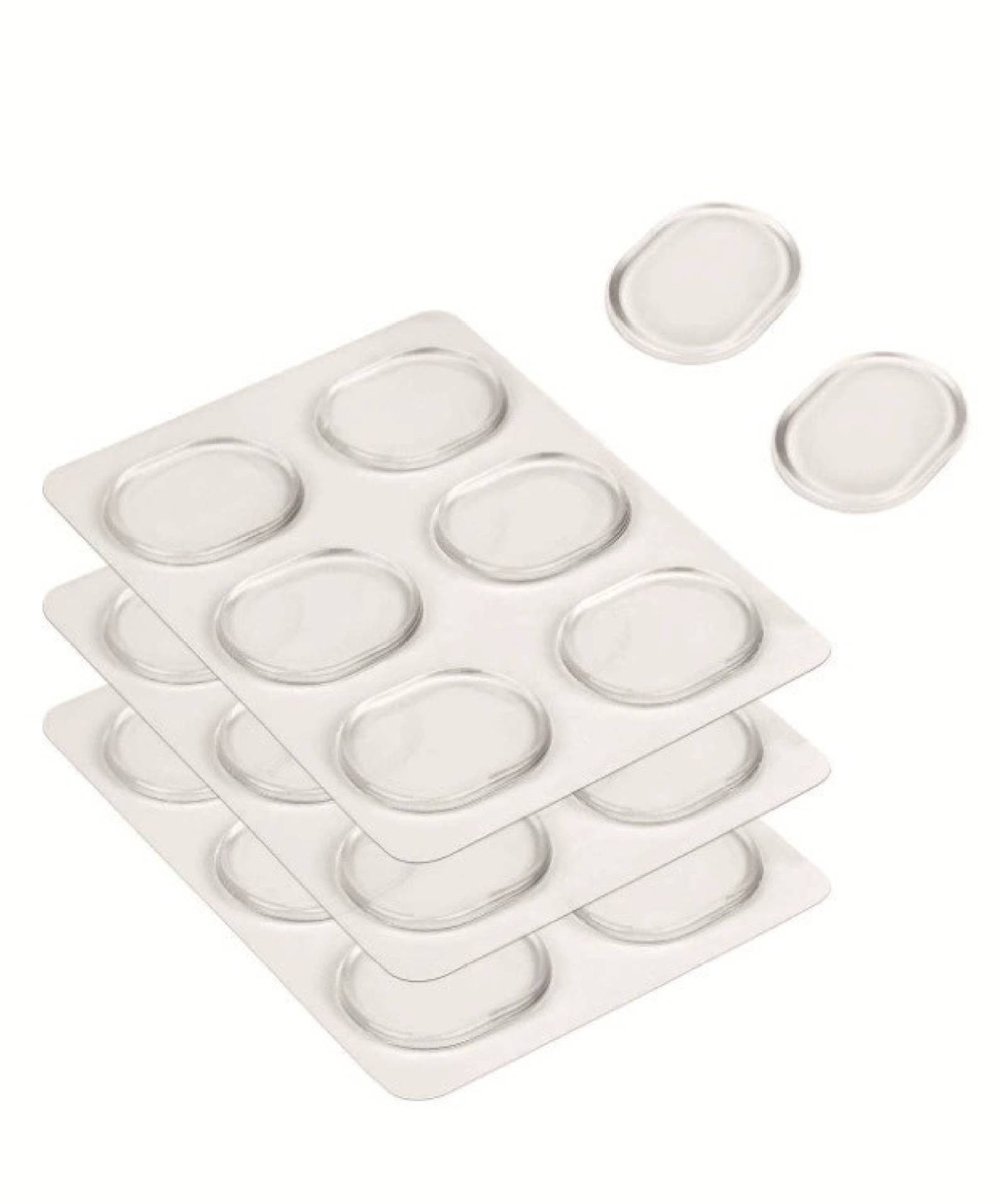 Stapel durchsichtiger Blisterpackungen mit ovalen transparenten Einsätzen, mit einigen losen Einsätzen, die in der Nähe auf weißem Hintergrund schweben.