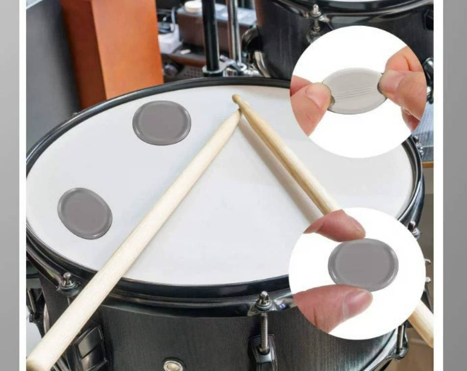 Übungsfläche für Schlagzeug mit zwei Drumsticks, zeigt abnehmbare Gummipolster auf der Oberfläche, mit eingefügten Nahaufnahmen der Polster, die von Hand angehoben werden.