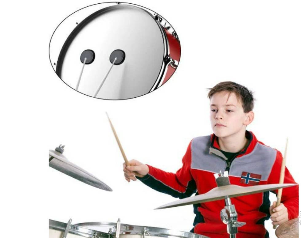 Junge Junge spielt ein Schlagzeug, gezeigt beim Schlagen der Trommeln mit Stöcken, mit einer Nahaufnahme des Schlagzeugpedal-Schlägermechanismus.