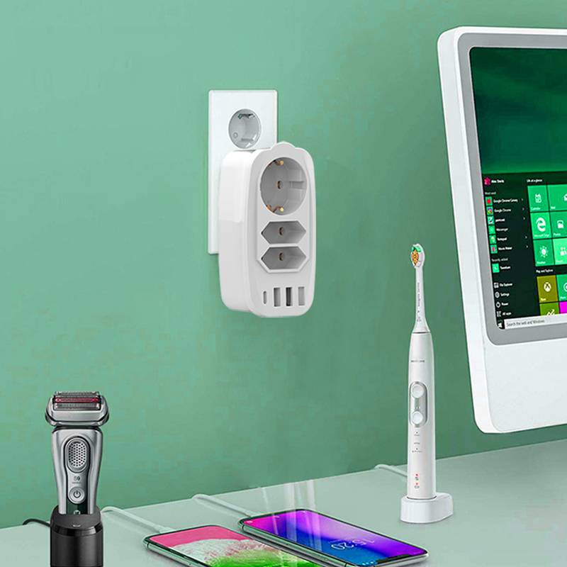 Schreibtischszene mit einem Wandladegerät, einem Elektrorasierer, einer Zahnbürste, einem Smartphone und einem Monitor, die darauf hindeuten, dass mehrere Geräte geladen oder verwendet werden.