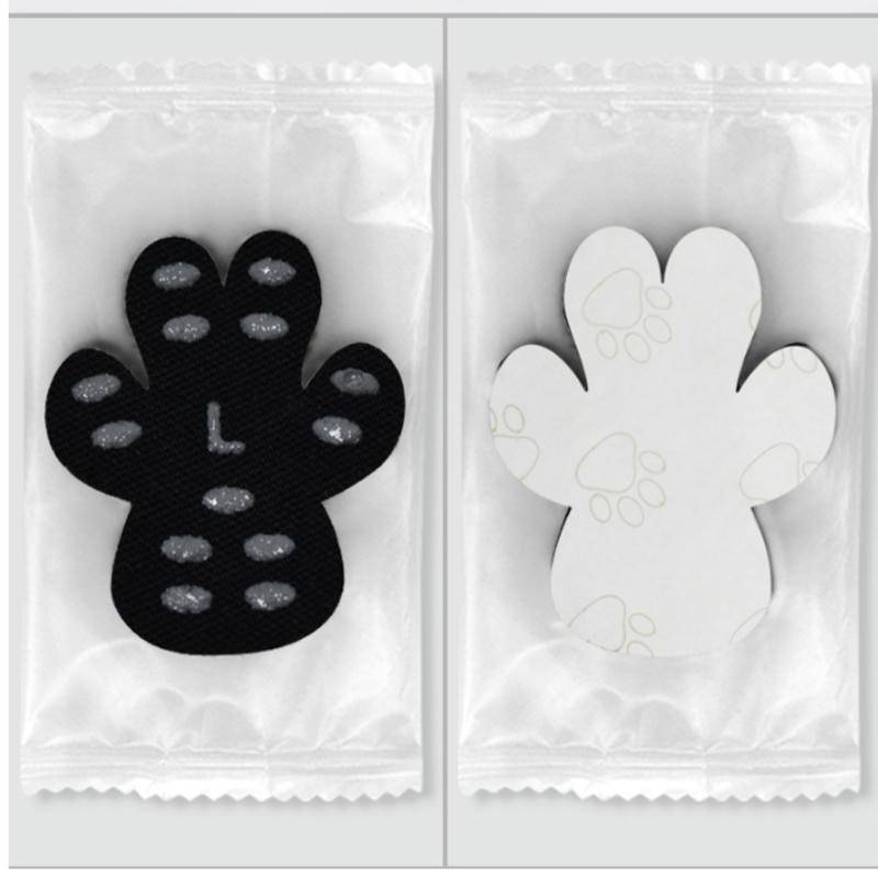 Zwei verpackte pfottenförmige Haftpads, eines schwarz und eines weiß, nebeneinander auf weißem Untergrund gezeigt.