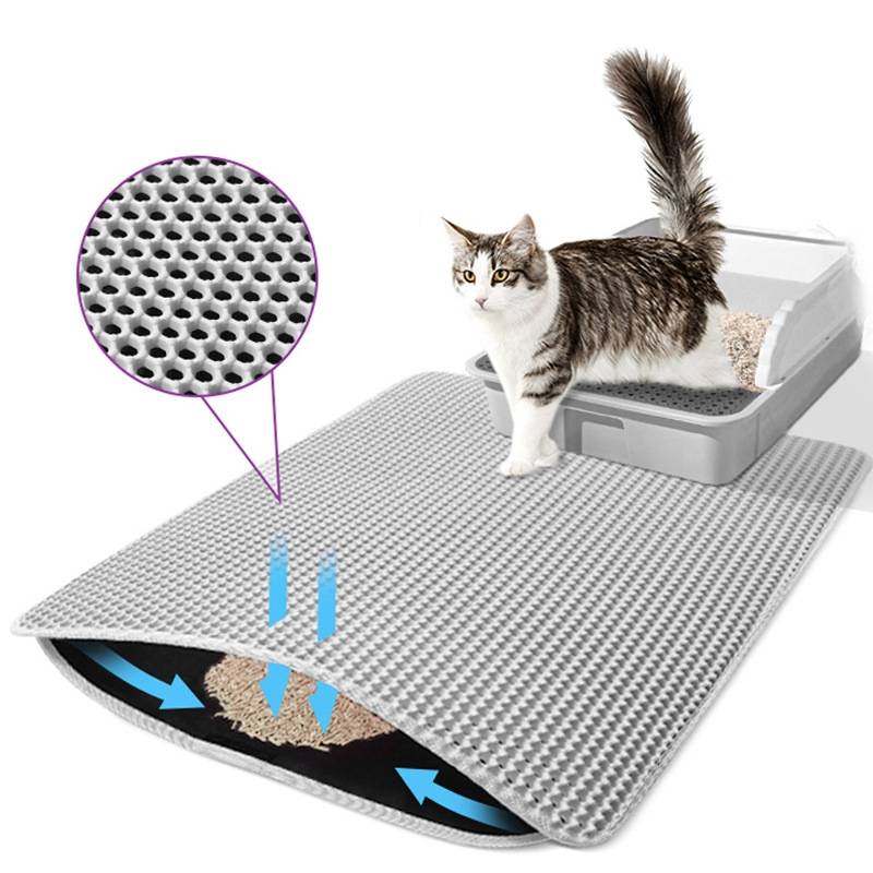 Katzenstreu-Matte mit Wabenstruktur fängt Streu auf und leitet Verschmutzung nach unten ab, gezeigt mit einer Katze, die neben einer Katzentoilette steht.