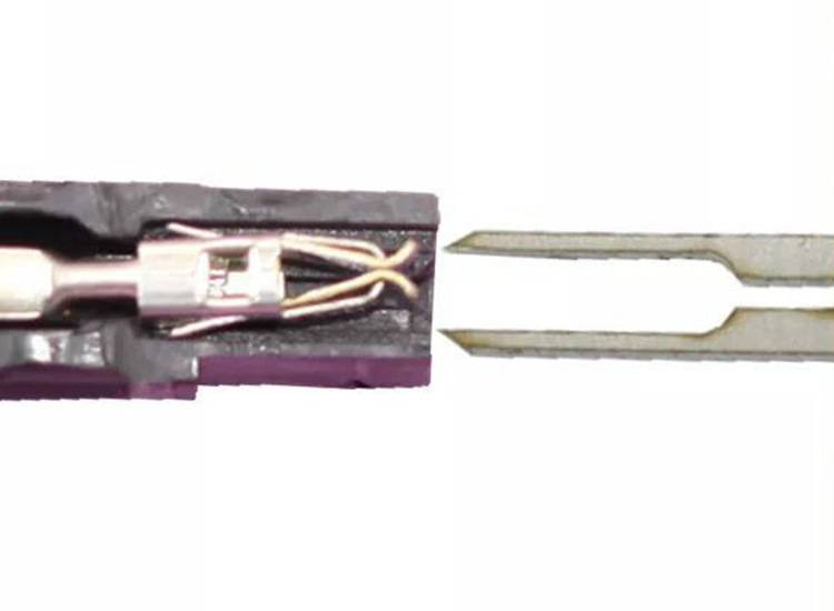 Nahaufnahme eines elektrischen Steckers, der abgezogen wird, mit zwei Metallklemmen und freiliegenden Drähten auf weißem Hintergrund.