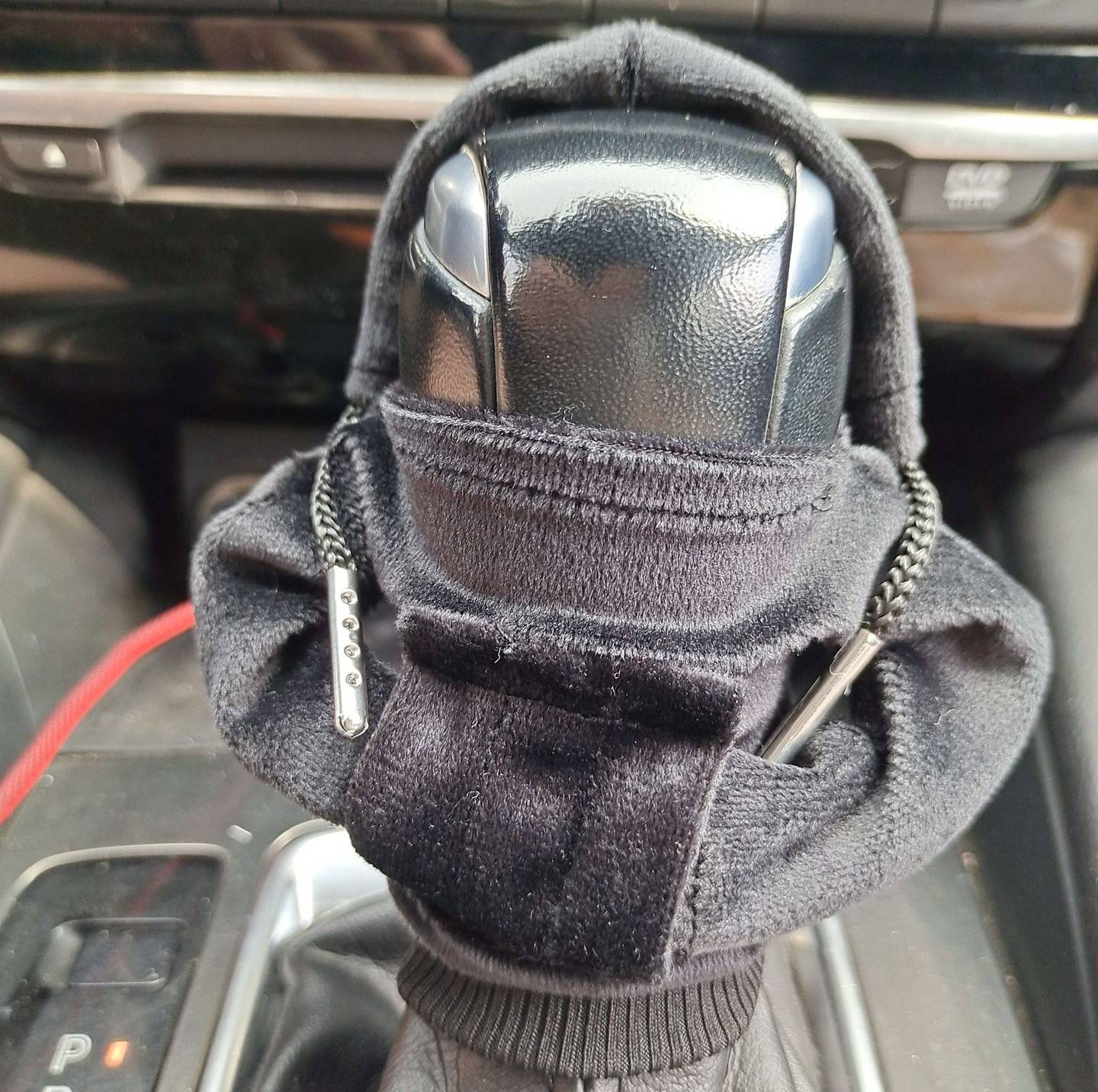 Nahaufnahme eines manuellen Schaltknaufs mit schwarzem Stoffüberzug in der Mittelkonsole eines Autos.