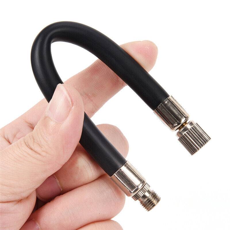 Hand, die einen kurzen schwarzen flexiblen Schlauch mit Metallgewindeverbindern an beiden Enden hält, auf weißem Hintergrund dargestellt.