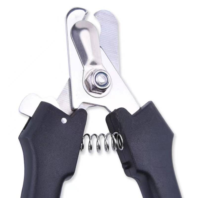 Nahaufnahme einer schwarzen Nagelschere mit Federmechanismus und Metallschneideklinge auf weißem Hintergrund.