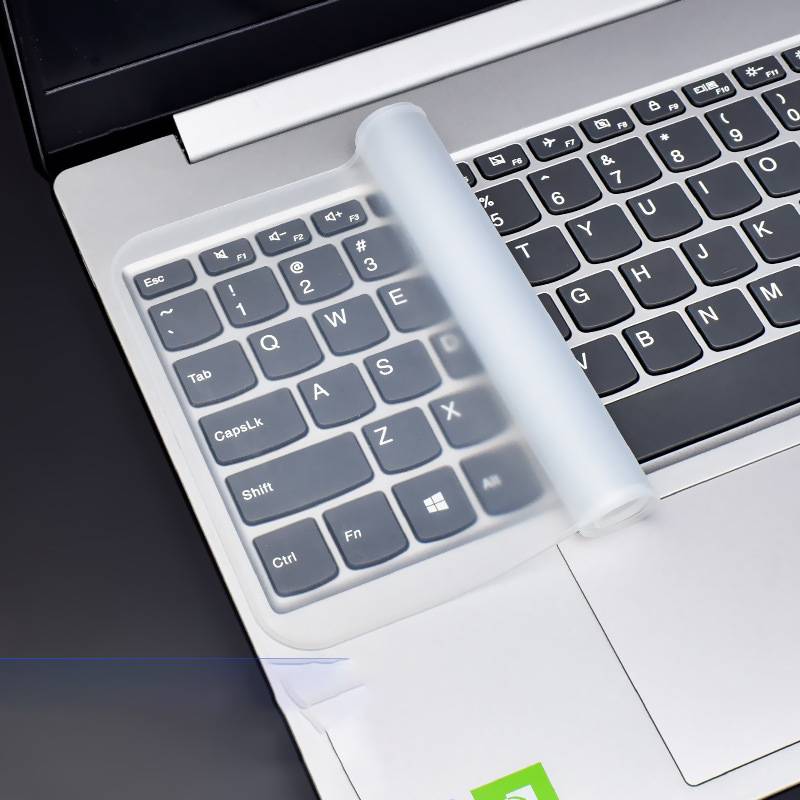 Nahaufnahme einer Laptop-Tastatur mit einer transparenten zylindrischen Walze, die diagonal über die Tasten und das Touchpad verläuft.