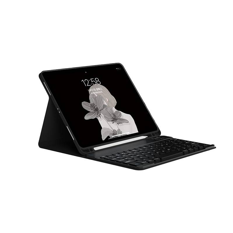 Schwarzes Tablet in einer Tastaturhülle, im Winkel wie ein Laptop geöffnet, mit grauer Blumentapete und 12:58 auf dem Bildschirm angezeigt.
