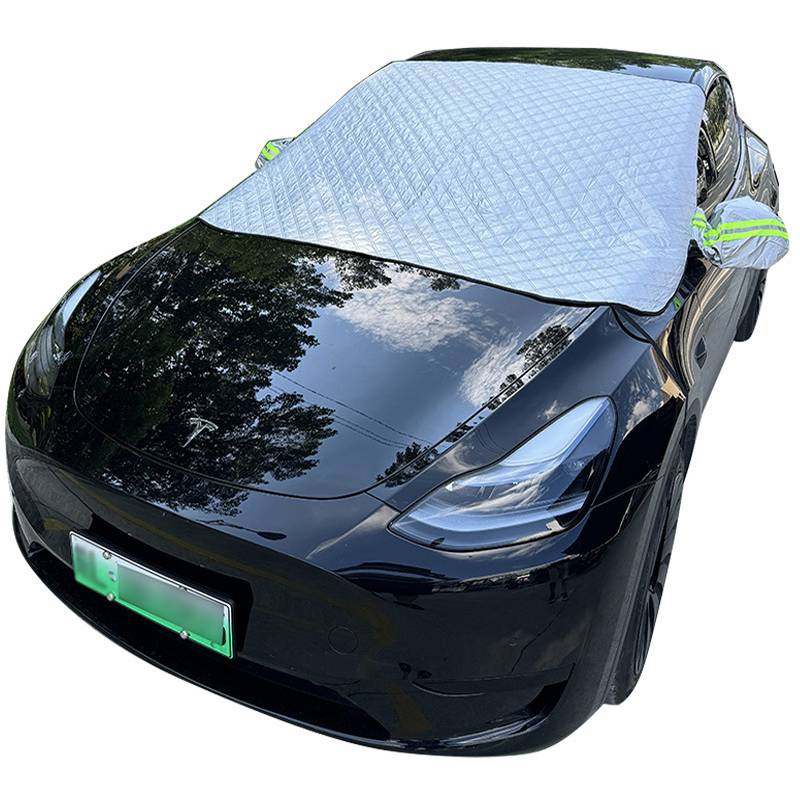 Schwarze Tesla-Limousine mit reflektierendem Windschutzschild für die Windschutzscheibe, das das Vorderfenster bedeckt, und eingeklappten oder umwickelten Seitenspiegeln, die im Freien geparkt ist.