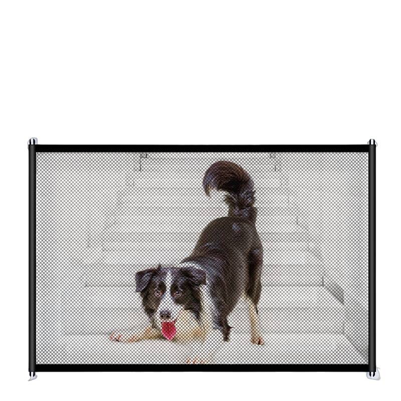 Kleiner Hund, der hinter einem Netz-Hundegitter auf weißem Boden steht und sich streckt, mit einem Spielzeug oder Kauartikel in der Nähe seines Mauls.