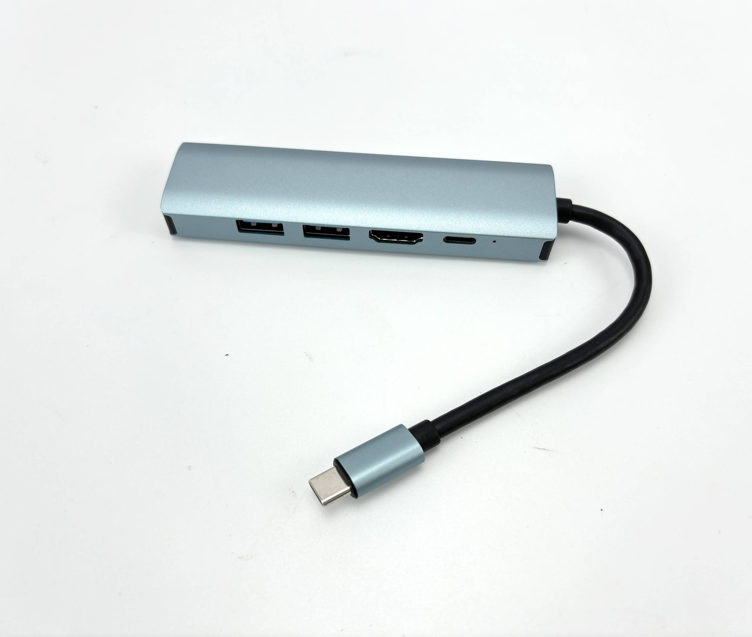 Kompakter silberner USB-C-Hub mit angebrachtem Kabel, der zwei USB-Anschlüsse, einen HDMI-Anschluss und einen USB-C-Anschluss auf weißem Hintergrund zeigt.
