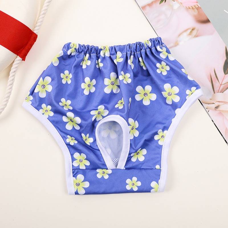 Blaue wiederverwendbare Schwimmwindel mit Blumenmuster oder Lernhose für Babys mit weißem Rand und absorbierender Polsterung, flach ausgebreitet dargestellt.