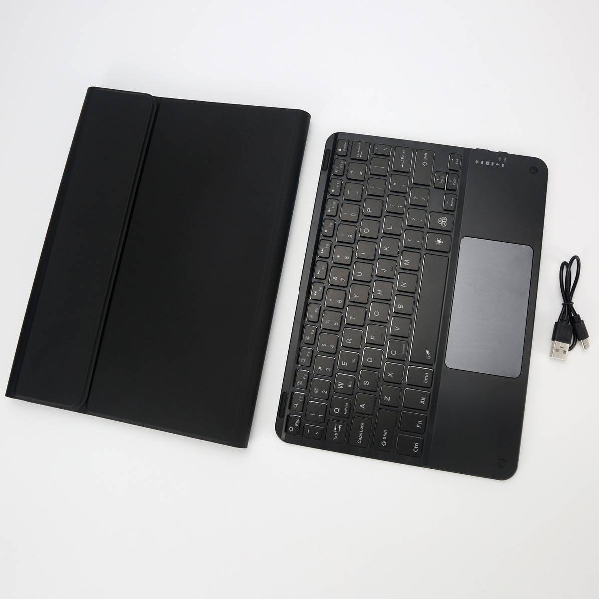 Schwarze Tablet-Tastaturhülle, abnehmbare Tastatur mit Touchpad und USB-Ladekabel auf weißem Hintergrund.