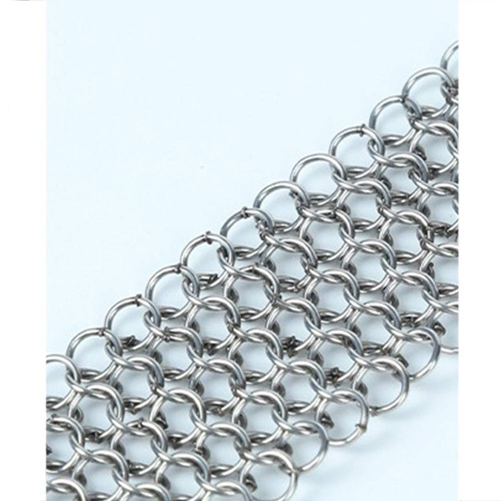 Nahaufnahme einer Kettenmasche aus ineinander verschlungenen silbernen Metallringen, die einen Kettenhemdstreifen auf hellem Hintergrund bildet.