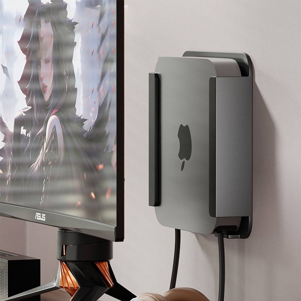 Apple Mac mini an der Wand montiert hinter einem ASUS-Monitor auf einer Wandhalterung, mit sichtbaren Kabeln, die ein kompaktes Schreibtisch-Setup schaffen.