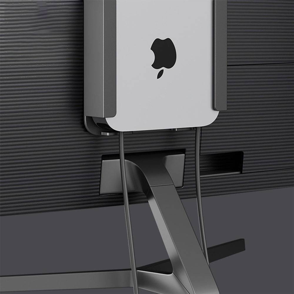 Apple Mac mini auf einer schwarzen Wandhalterung montiert mit Kabeln, die darunter hängen