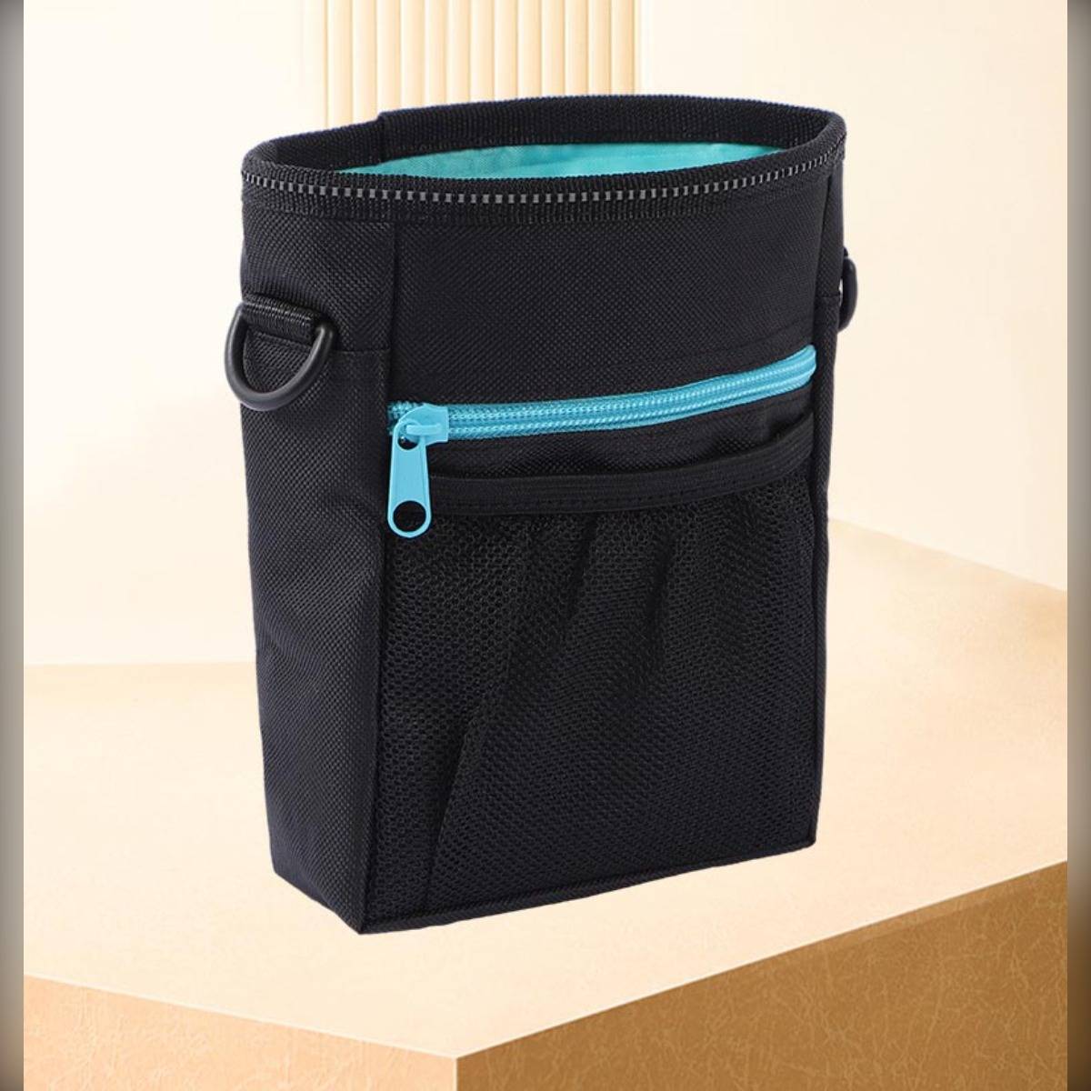 Schwarze Stoffhängeorganizer-Tasche mit türkisfarbenem Reißverschluss und seitlichen Schlaufen, aufgestellt auf einer Oberfläche gezeigt.
