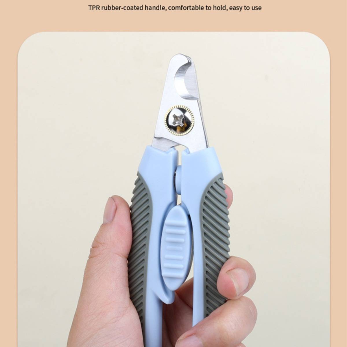 Nahaufnahme einer Hand, die eine blaugraue Haustiernagel-Schere mit gummibeschichtetem, ergonomischem Griff hält.