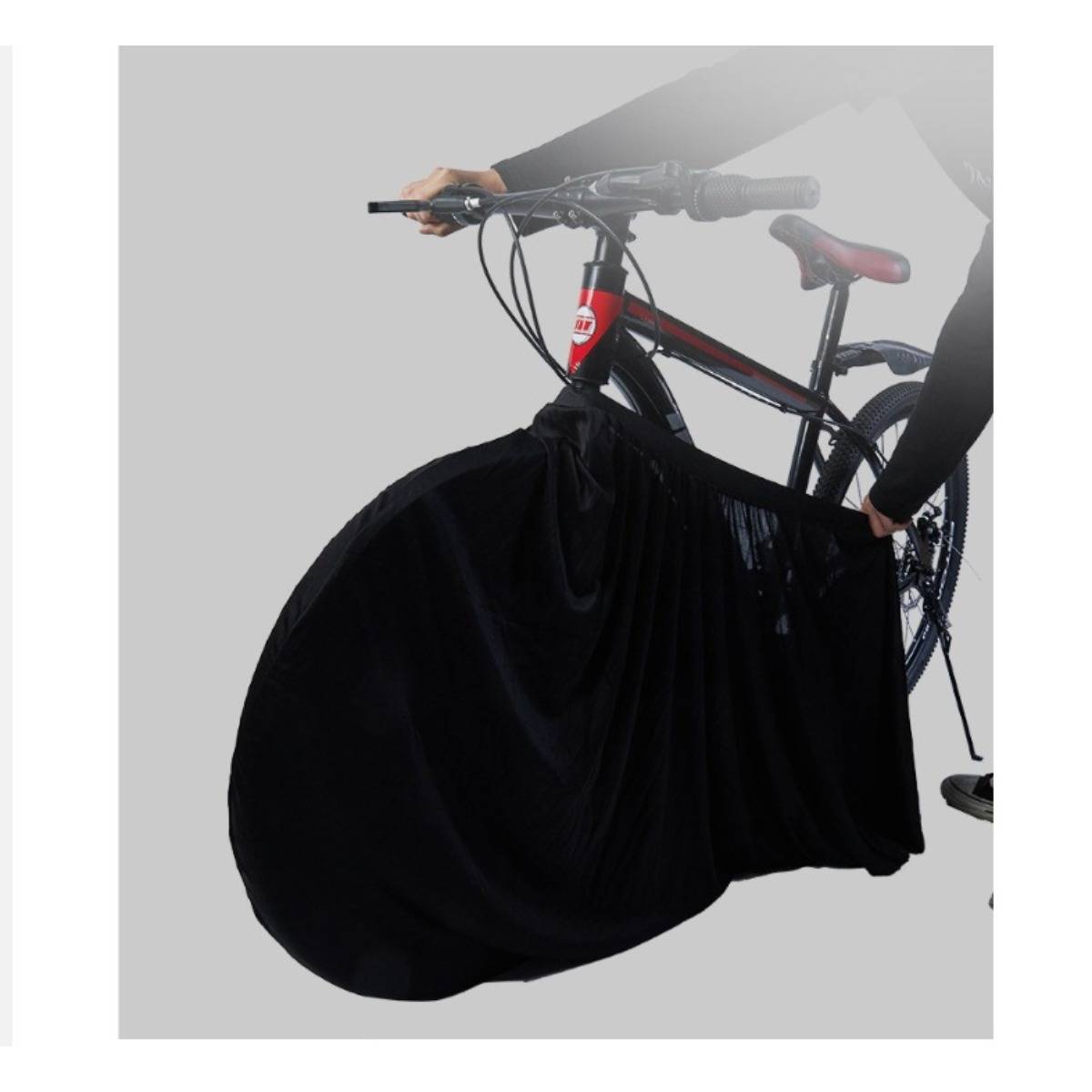 Eine Person hält ein Fahrrad mit einer großen schwarzen Radabdeckung oder Tasche, die ein Fahrradspeicher- oder Transportzubehör zeigt.