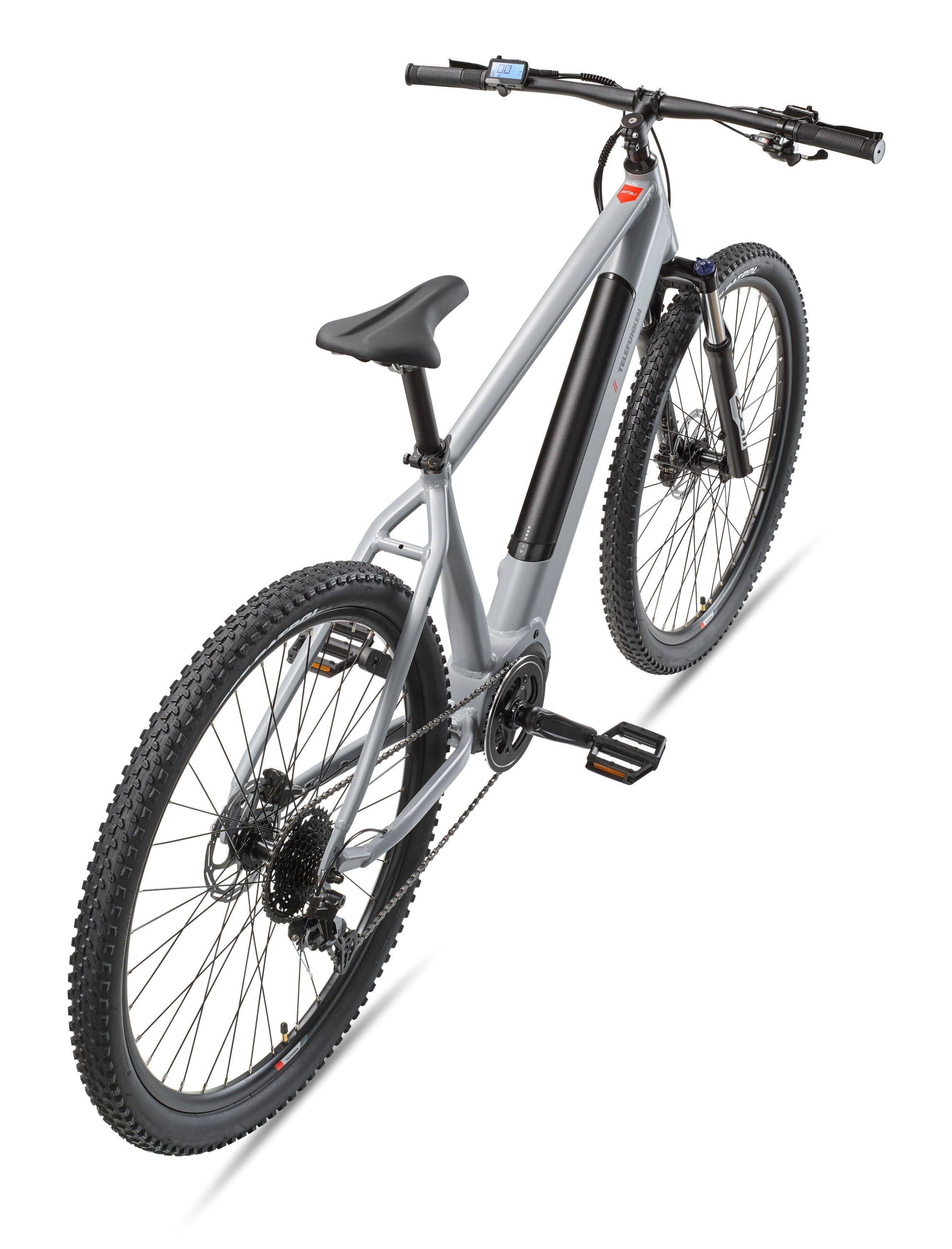 Silbernes Mountainbike in schräger Ansicht auf weißem Hintergrund, mit dicken Stollenreifen, flachen Lenkern und einer Federgabel vorne.