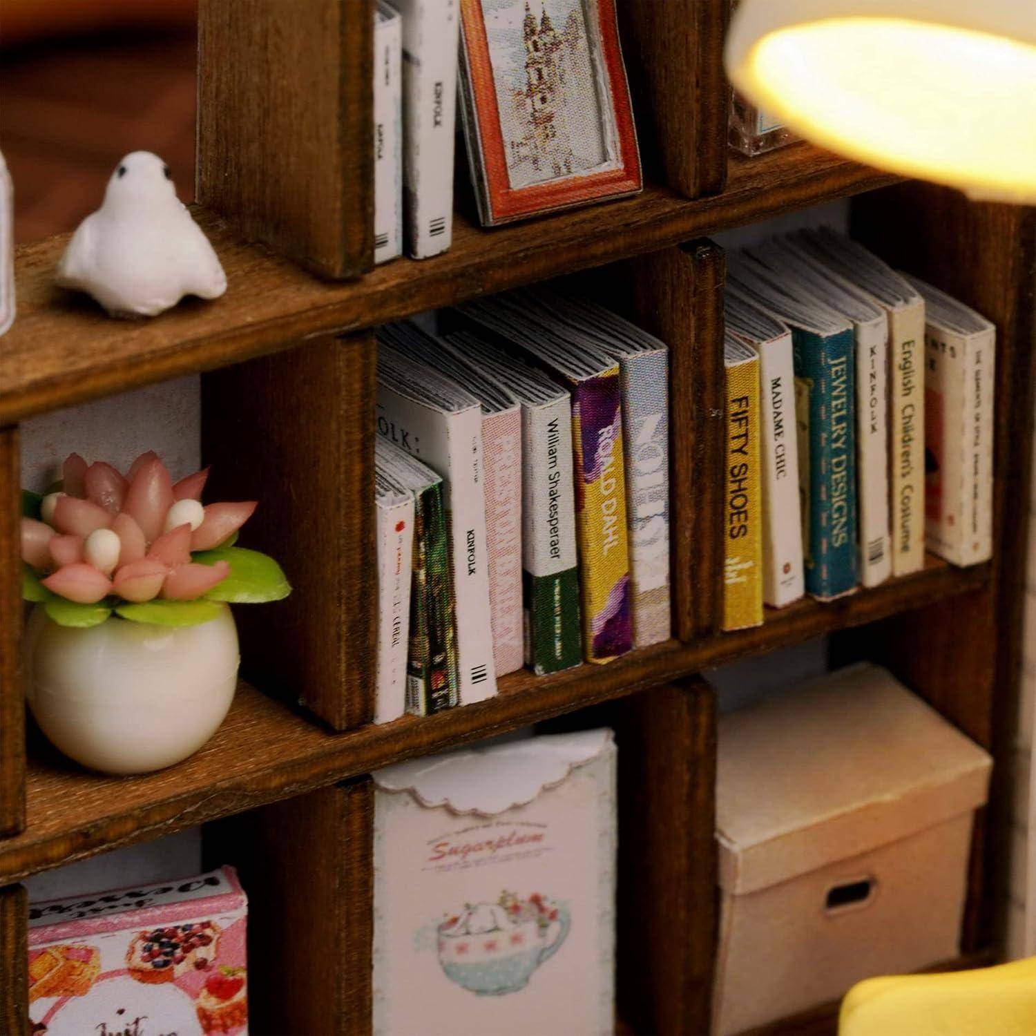 Hölzernes Bücherregal mit ordentlich angeordneten Büchern, eine kleine weiße Vogelfigurine, eine Blumenverzierung und Aufbewahrungsboxen; eine gelbe Lampe leuchtet am Rand.