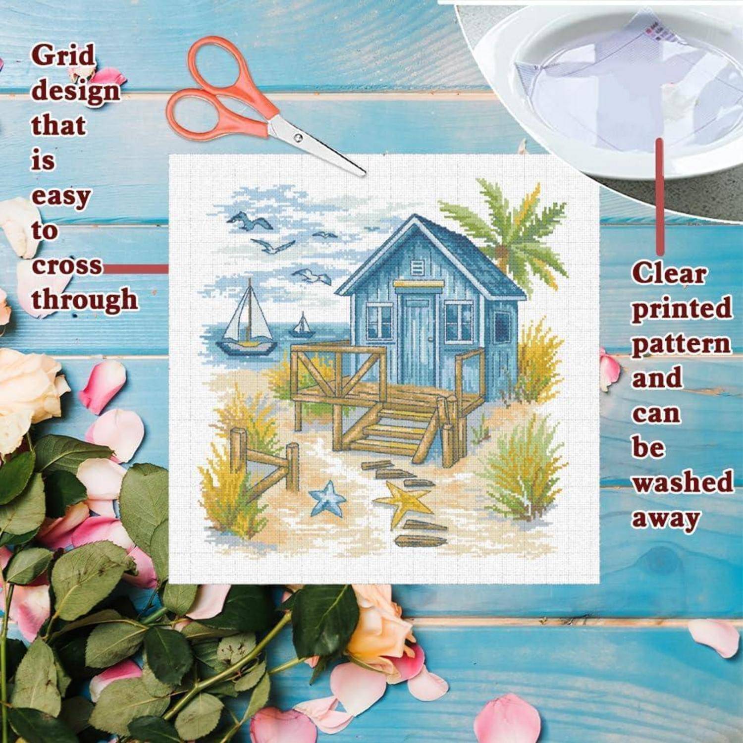 Vorschau des Kreuzstichmuster auf Stoff, das eine Strandhhütte am Wasser mit Segelbooten und Seesternen zeigt; der Text vermerkt das einfache Gitterdesign und das waschbare, klar bedruckte Muster.