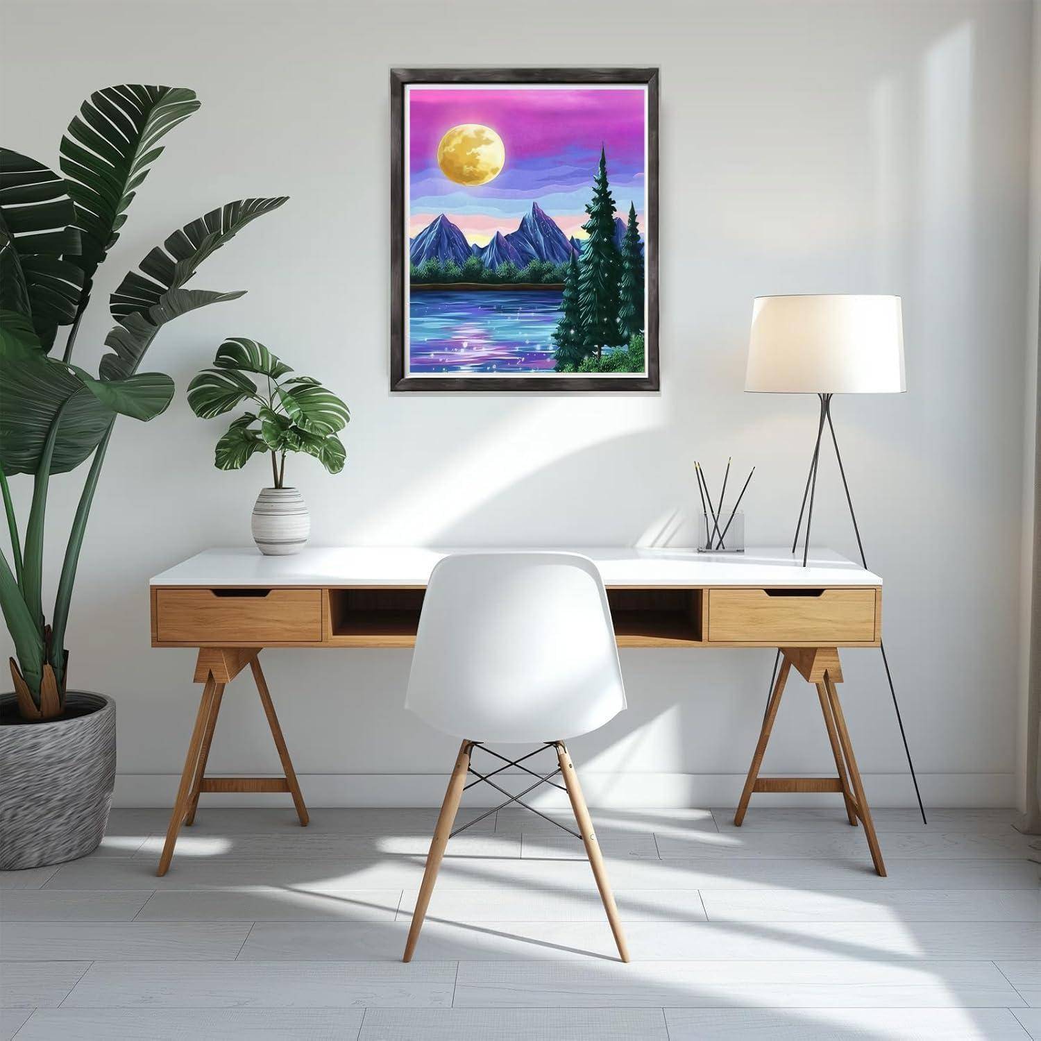 Minimales Homeoffice mit weißem Schreibtisch, Stuhl, Stehleuchte und Topfpflanzen; gerahmte Berglandschaft mit Mond über dem Schreibtisch.