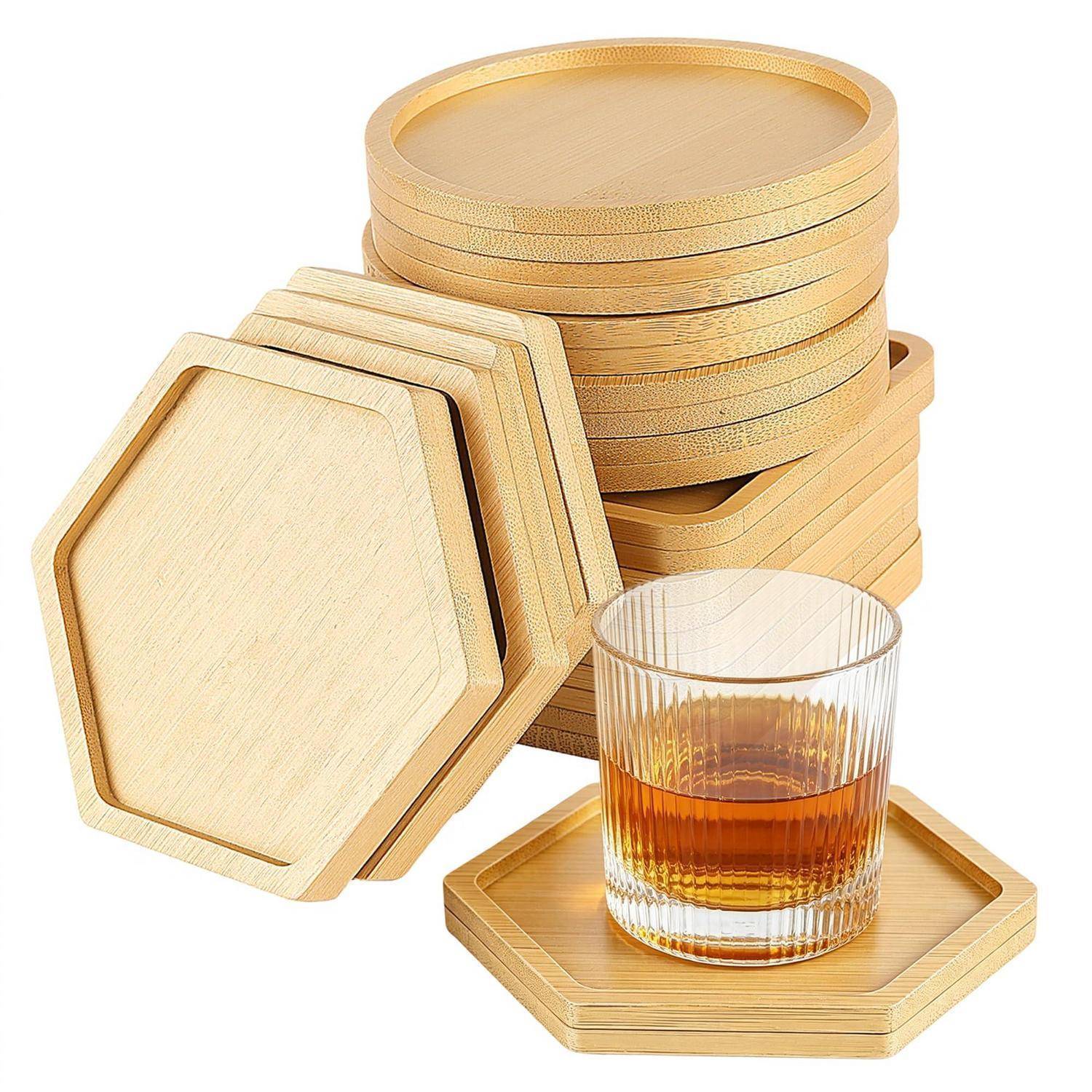 Stapel von sechseckigen hölzernen Untersetzer und ein passendes Tablett mit einem Glas Bernsteingetränk auf weißem Hintergrund.