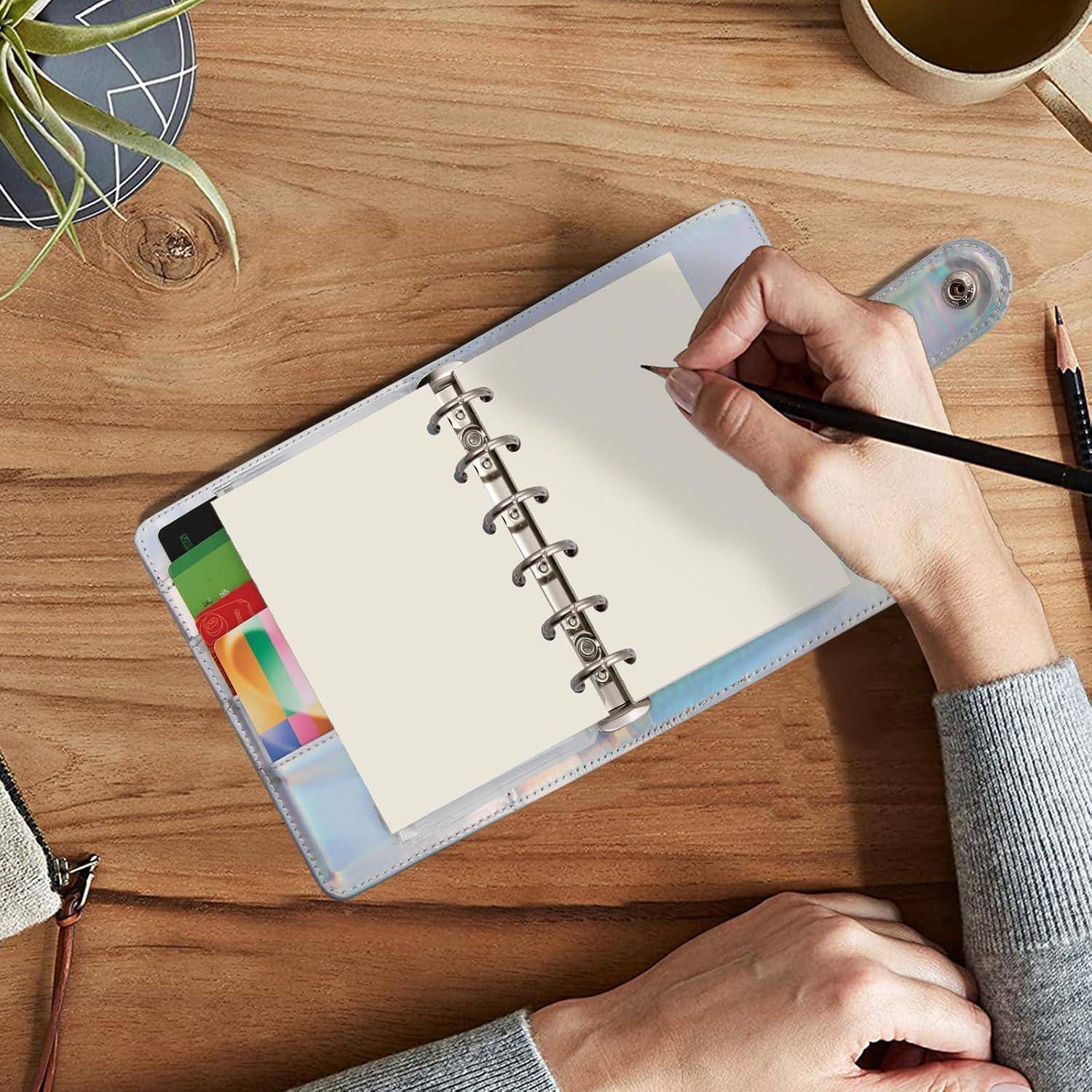 Handschrift in einem leeren Spiralblock auf einem Holzschreibtisch, mit einer Kaffeetasse, einer Pflanze und Bleistiften in der Nähe.
