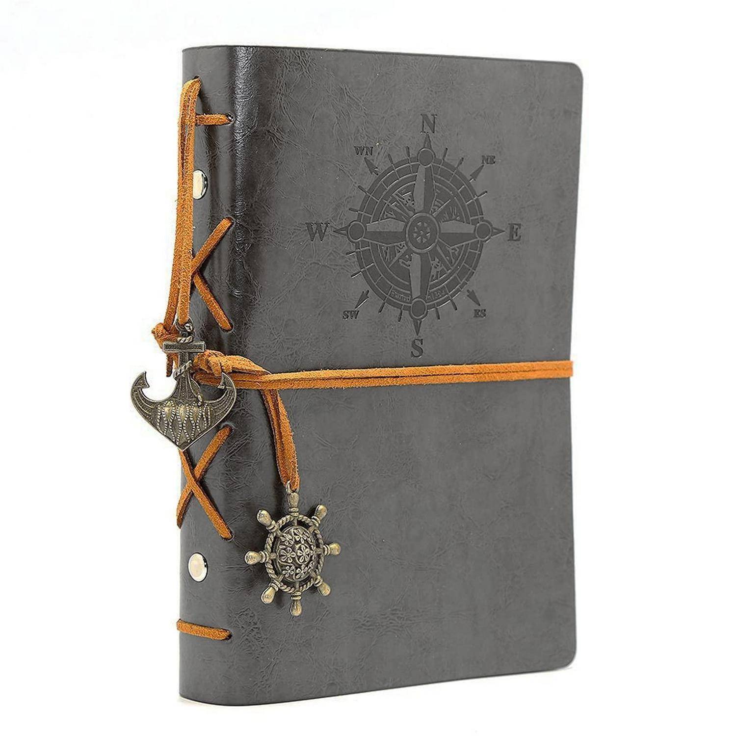 Schwarzes Ledertagebuch mit Kompassemblem, gebunden mit einer orangefarbenen Schnur und verziert mit einem hängenden Anker- und Schiffsrad-Charm.