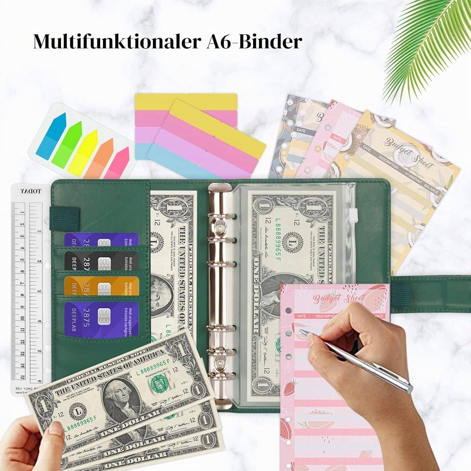 Ein grüner multifunktionaler A6-Binder-Organizer mit sechsringigem Metallrücken, Geldtaschen, Kartenfächern und einer Handschrift auf einem rosa Einsatz; der Titel lautet „Multifunktionaler A6-Binder