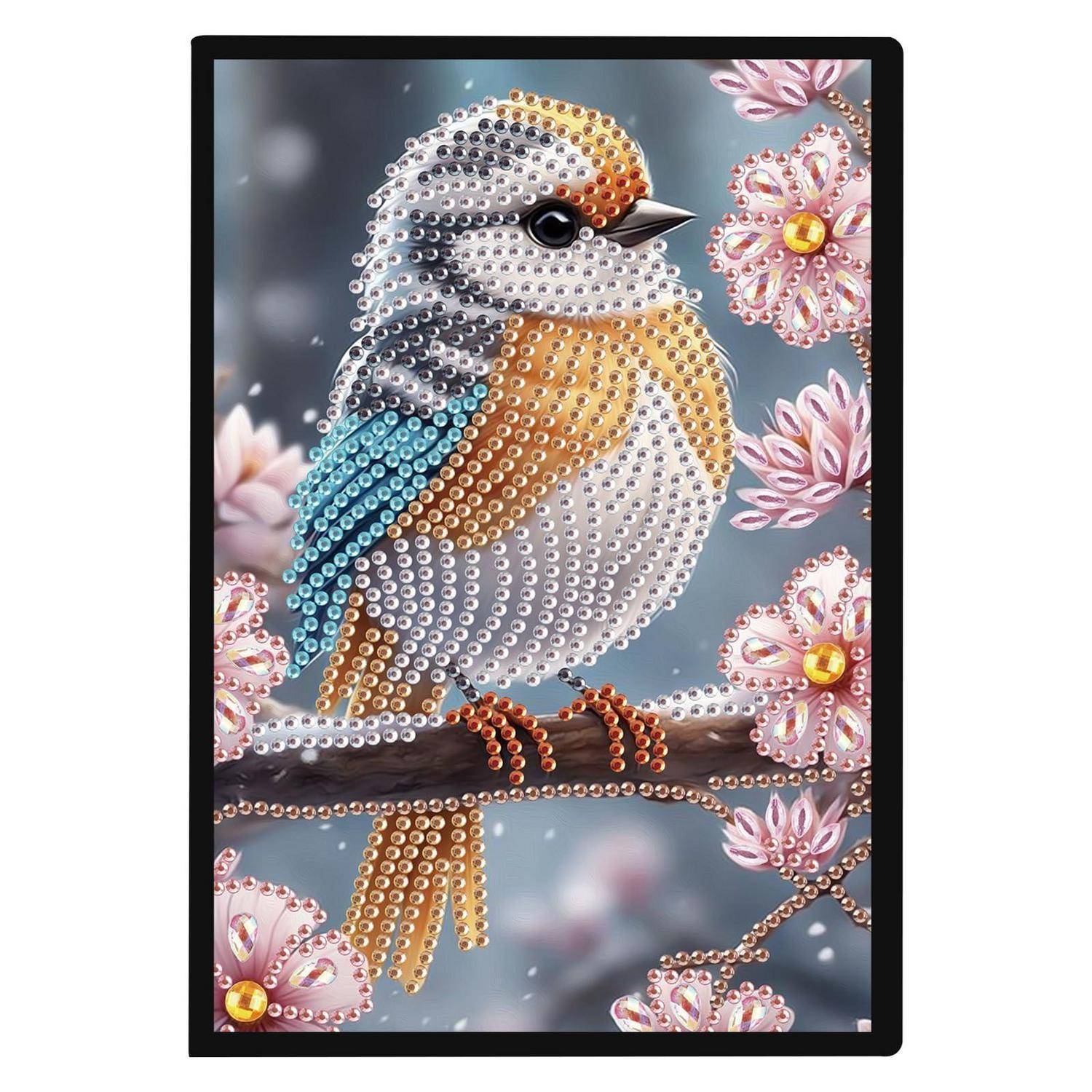 Kunstwerk aus Perlen einer Vogels auf einem Ast, umgeben von rosa Blüten auf grauem Hintergrund.