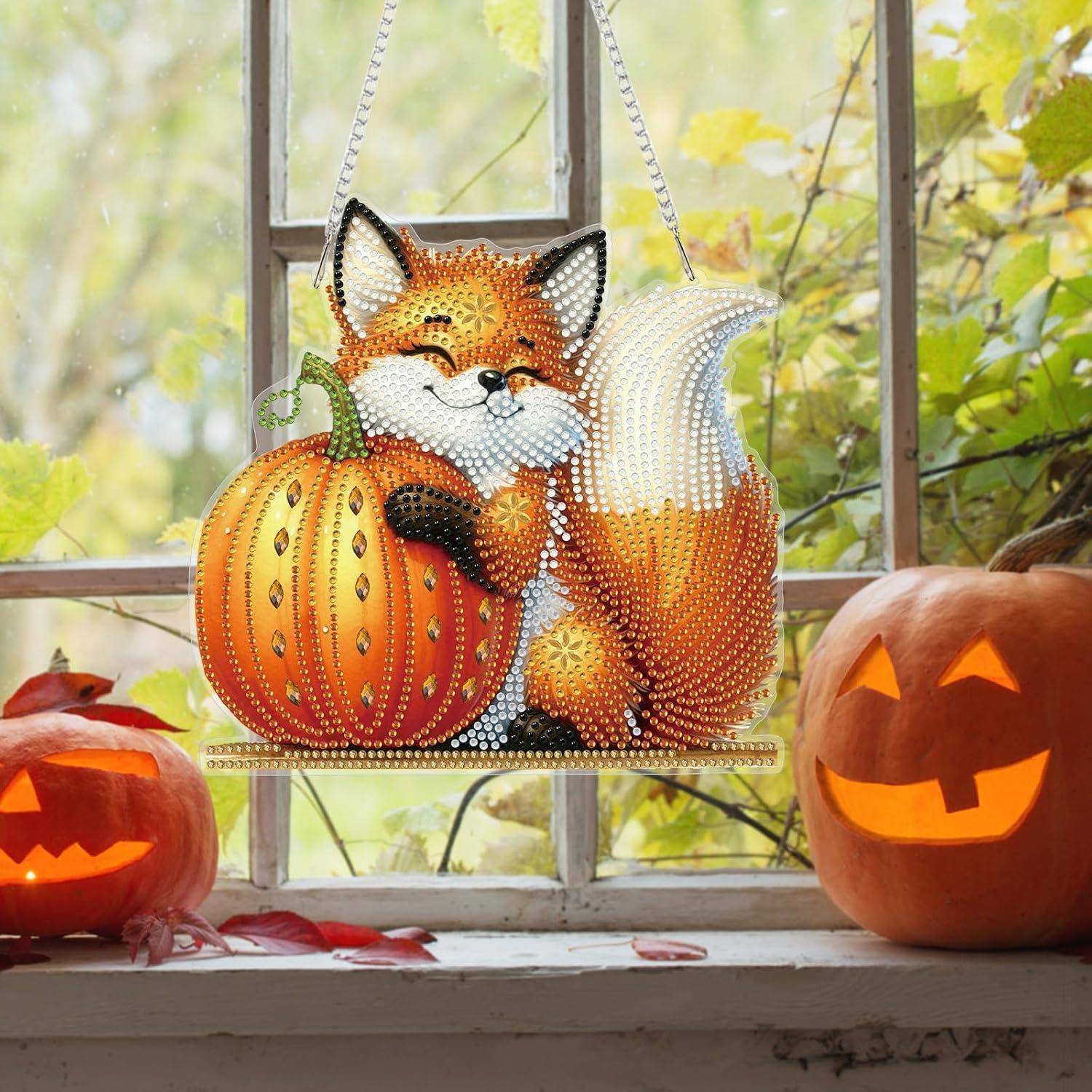 Eine geschmückte Fuchsfigur mit Juwelen sitzt neben einem Kürbis, mit zwei leuchtenden geschnitzten Kürbislaternen auf einer Fensterbank in einer herbstlichen Umgebung.