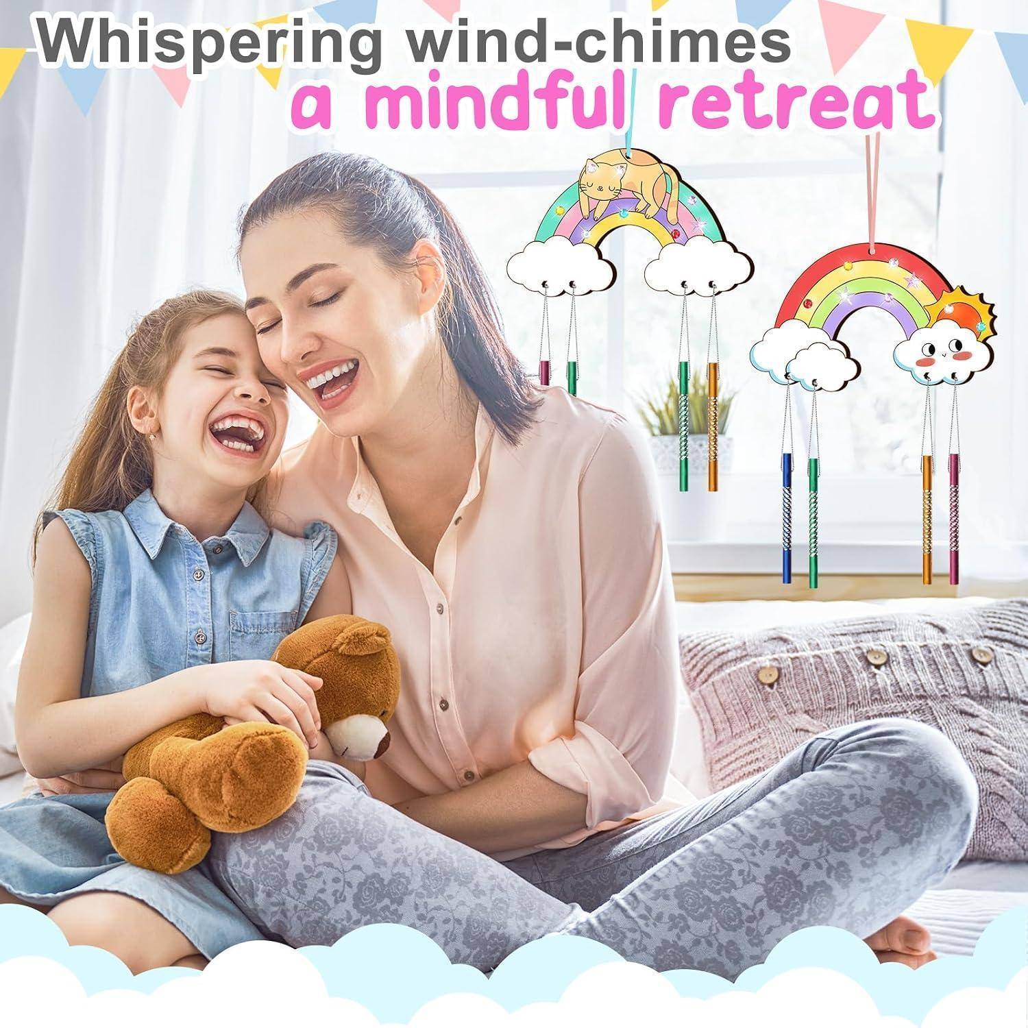 Mutter und Tochter lachen auf einem Bett neben regenbogenfarbenen Wolken-Windspiele; der Text lautet „Flüsternde Windspiele – ein achtsamer Rückzugsort