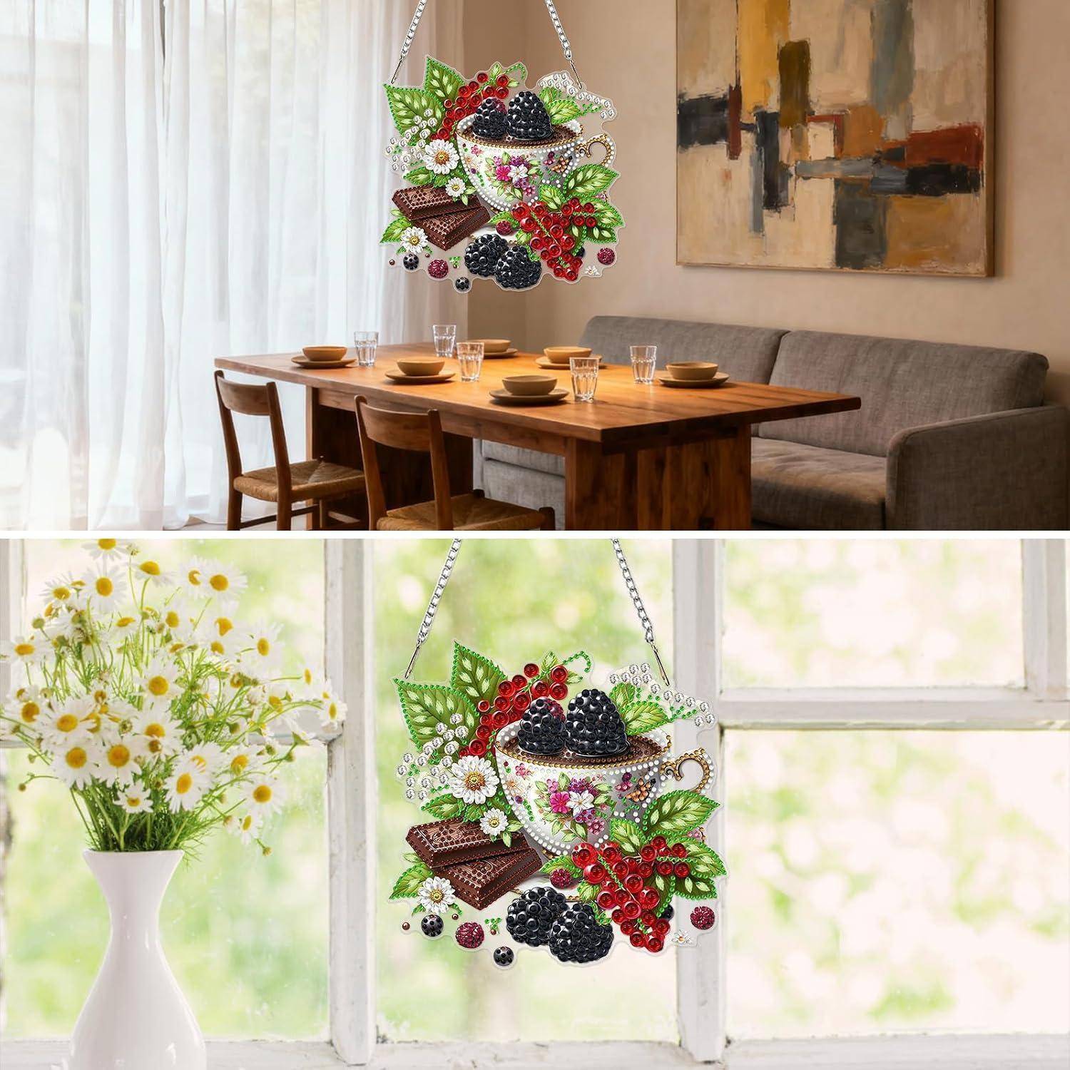 Zwei Fotos zeigen ein perlenbesetztes Obst- und Schokoladenschmuckstück, das in einem Wohnzimmer mit Essbereich hängt und neben einem Fenster neben Blumen in einer weißen Vase.