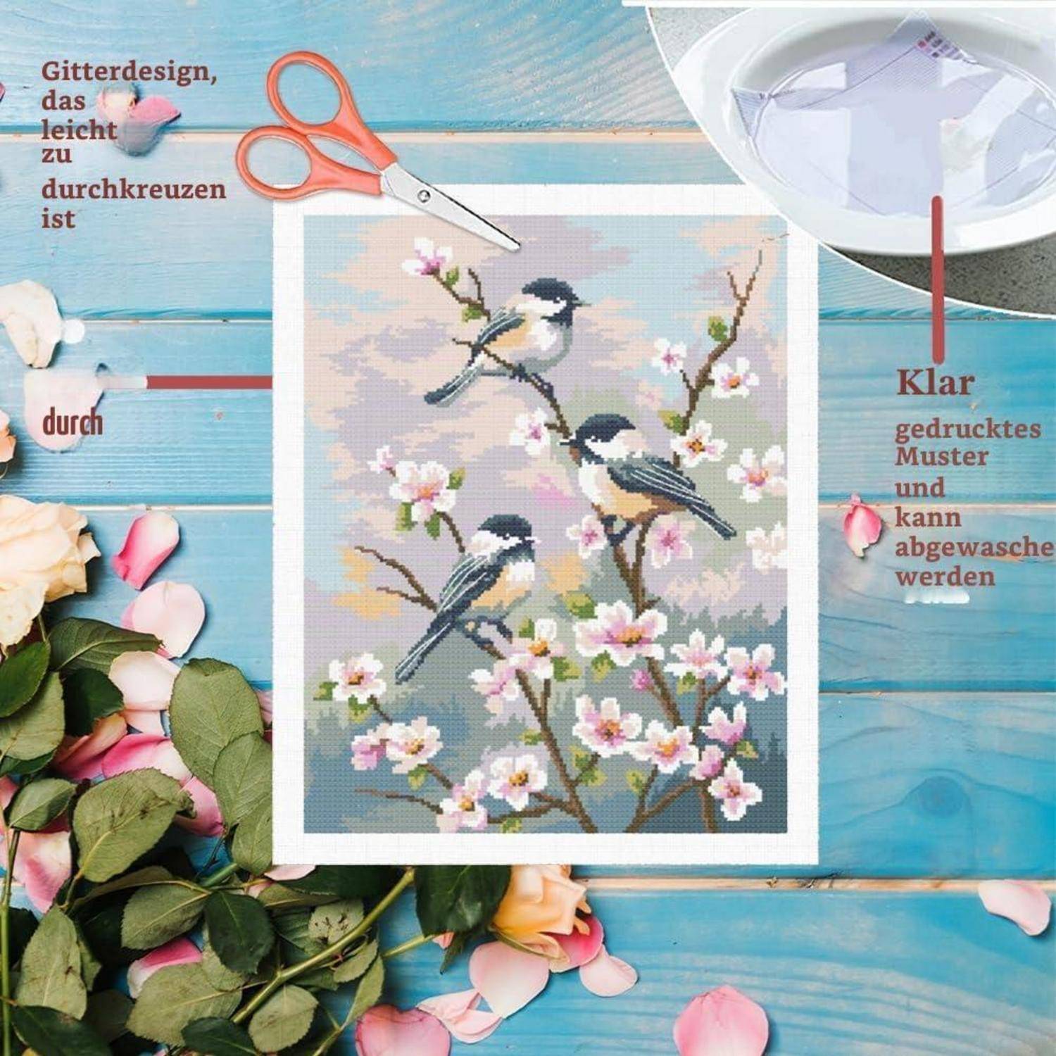 Drei Vögel auf blühenden Zweigen in einem Kreuzstich-Design, ausgeschnitten mit Schere und gezeigt mit deutschem Text über einfaches Kreuzsticken und waschbares bedrucktes Muster.