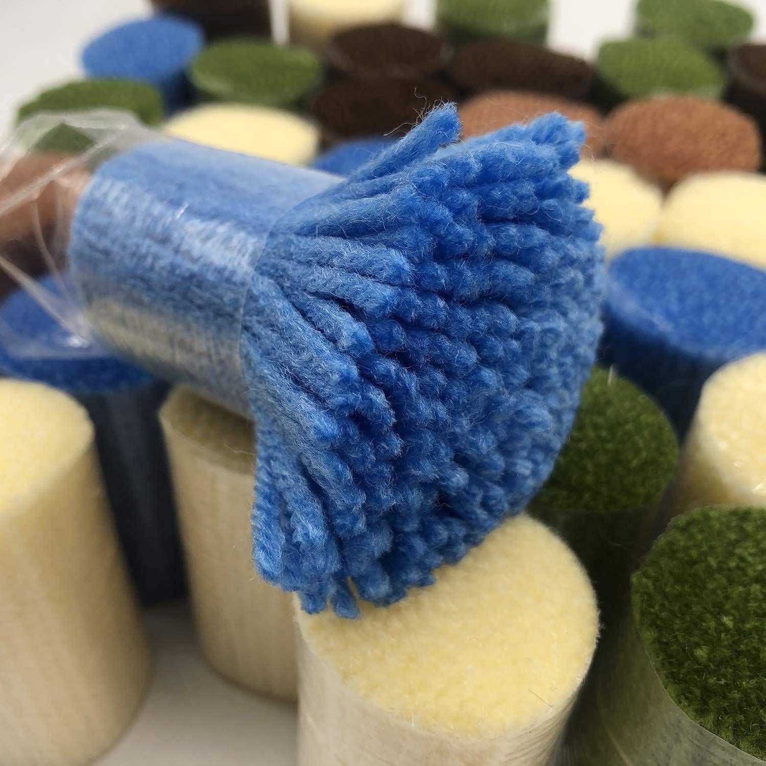 Nahaufnahme eines blauen Pinsels mit weichen Borsten, der zwischen bunten zylindrischen Farbmustern oder Musterkarten ruht.