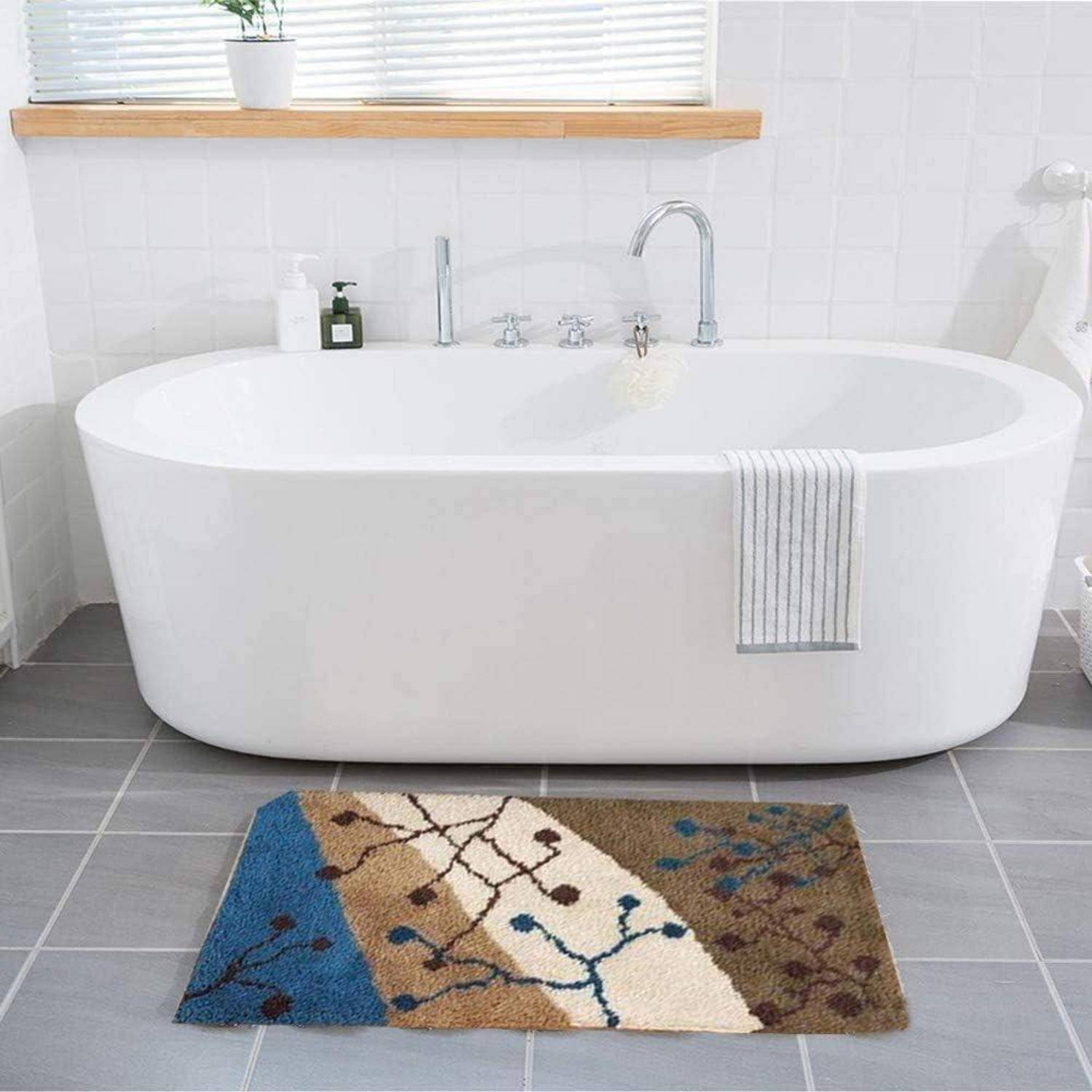 Modernes Badezimmer mit einer freistehenden weißen Badewanne, Fliesenboden und farbenfrohem Badezimmerteppich im Vordergrund.
