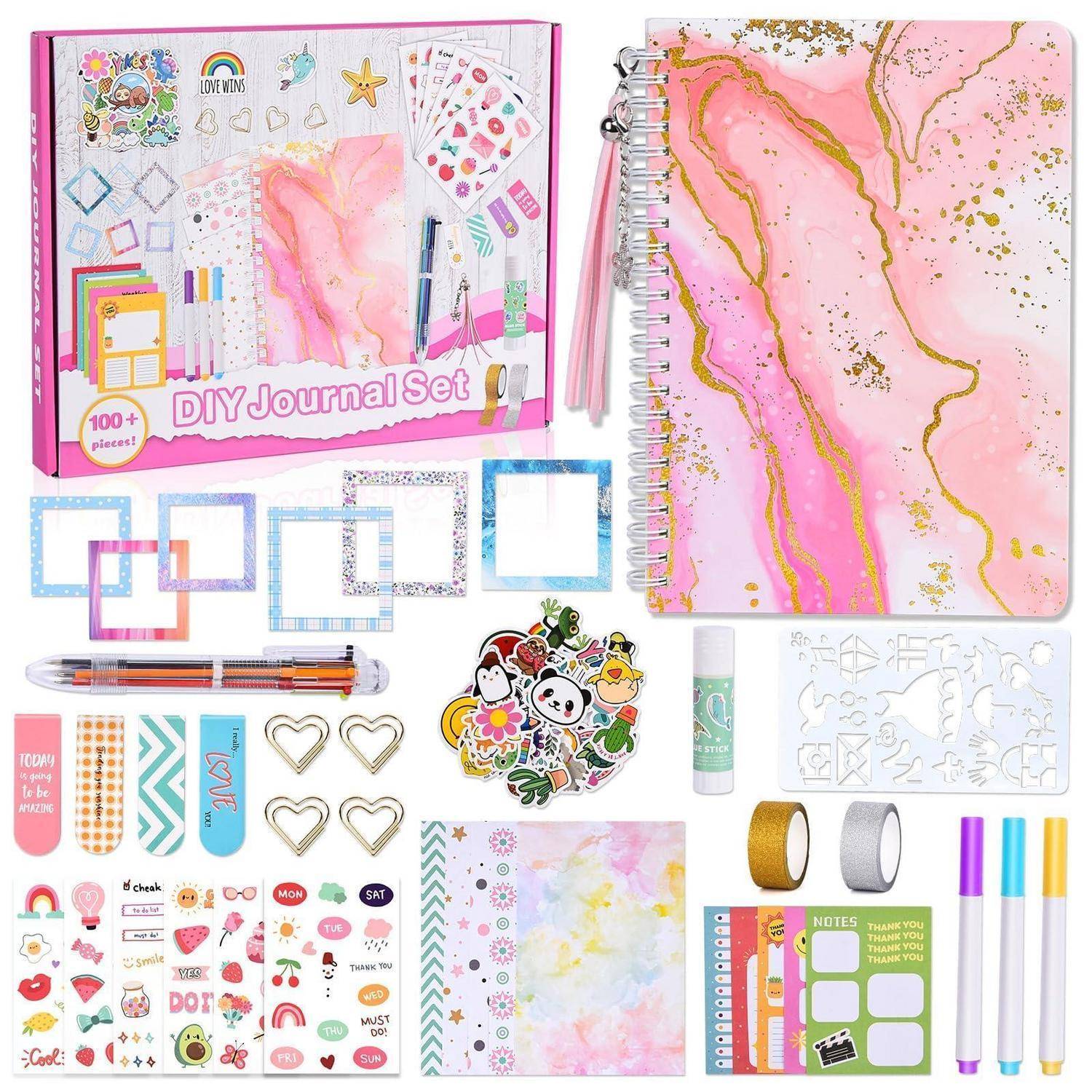DIY-Journalset mit rosa Spiralnotizbuch, dekorativen Aufklebern, Stiften, Schablonen, Washi-Tape, Herzklammern und verschiedenen Bastelzubehörteilen in Verpackung.