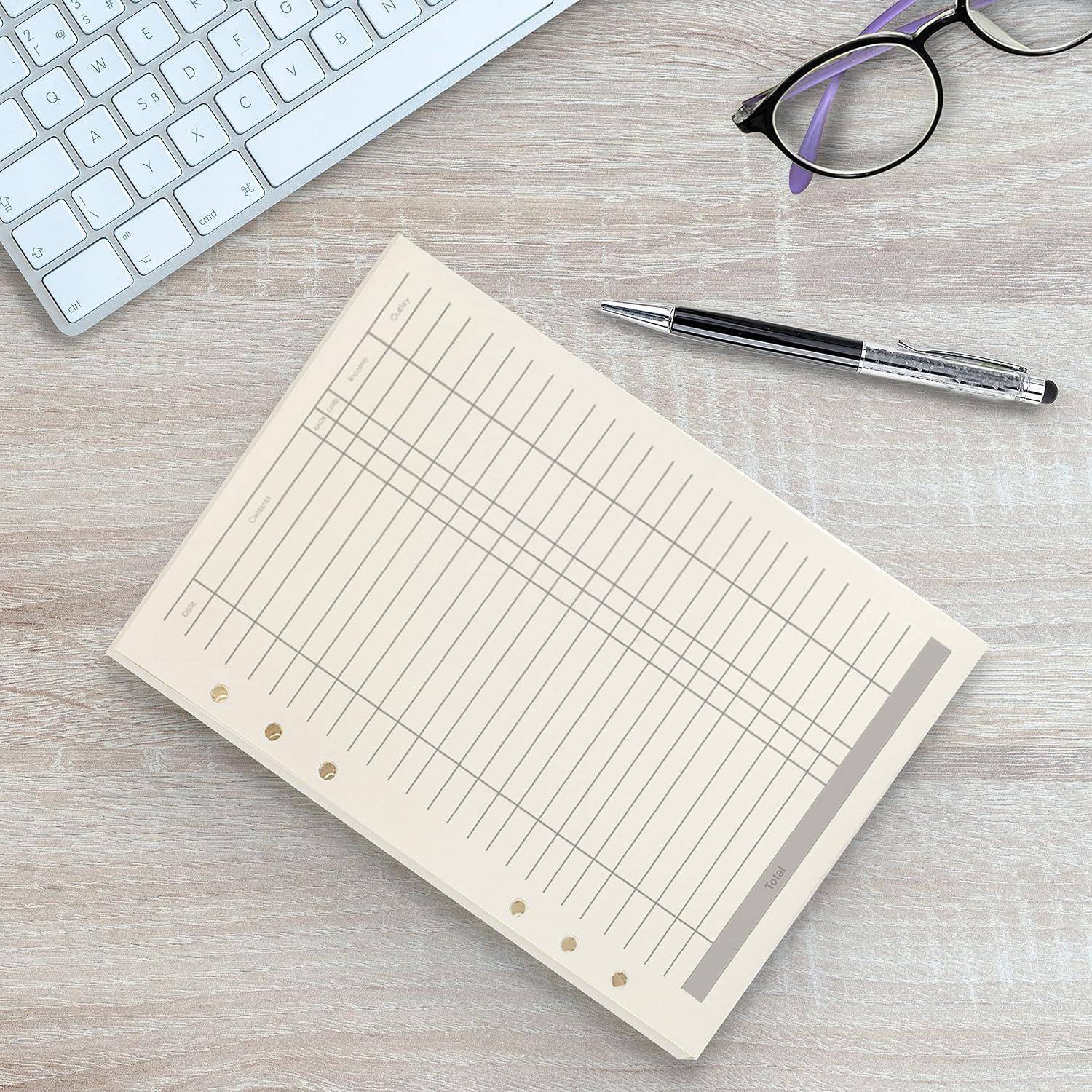 Schreibtisch mit einem leeren linierten Notizbuch, Stift, Brille und Tastatur auf einer hellen Holzoberfläche.