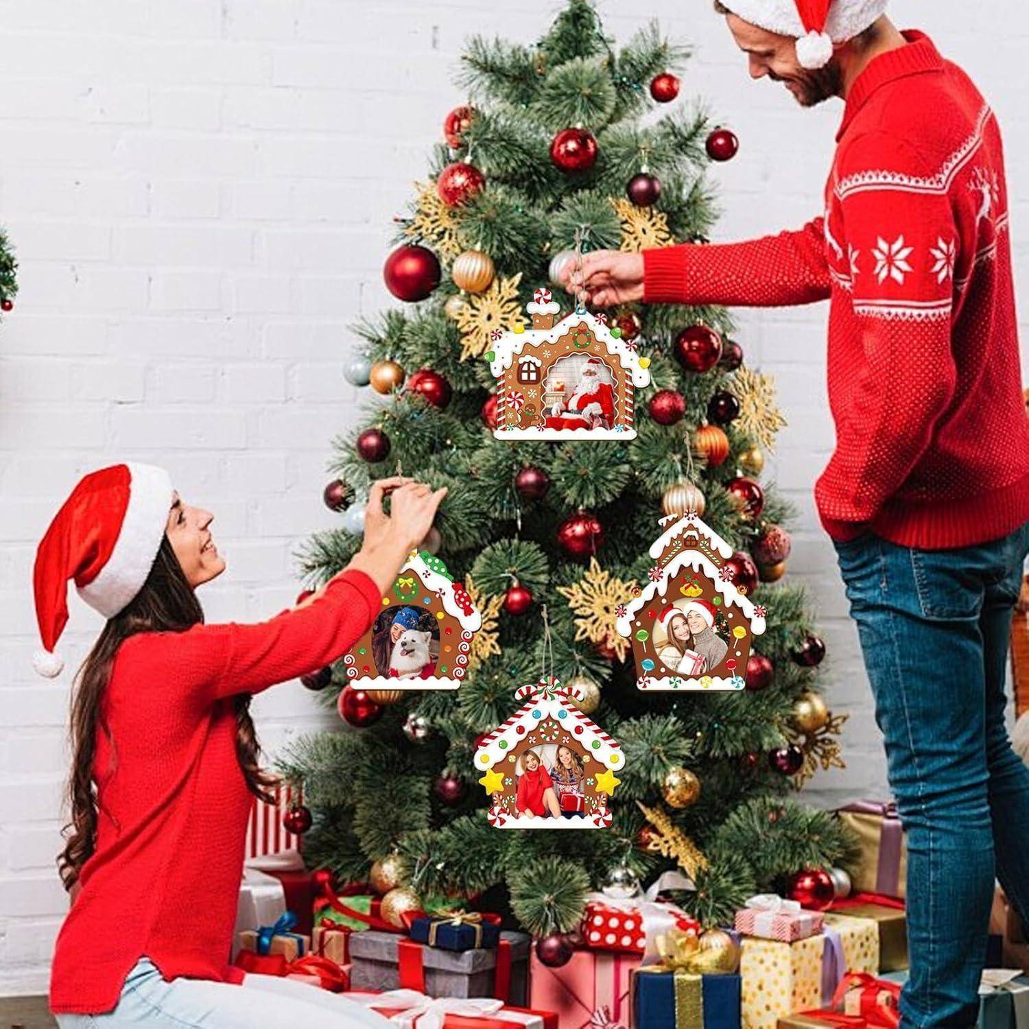 Ein Paar in Weihnachtsmützen schmückt einen Weihnachtsbaum mit Lebkuchenornamenten und verpackten Geschenken darunter.