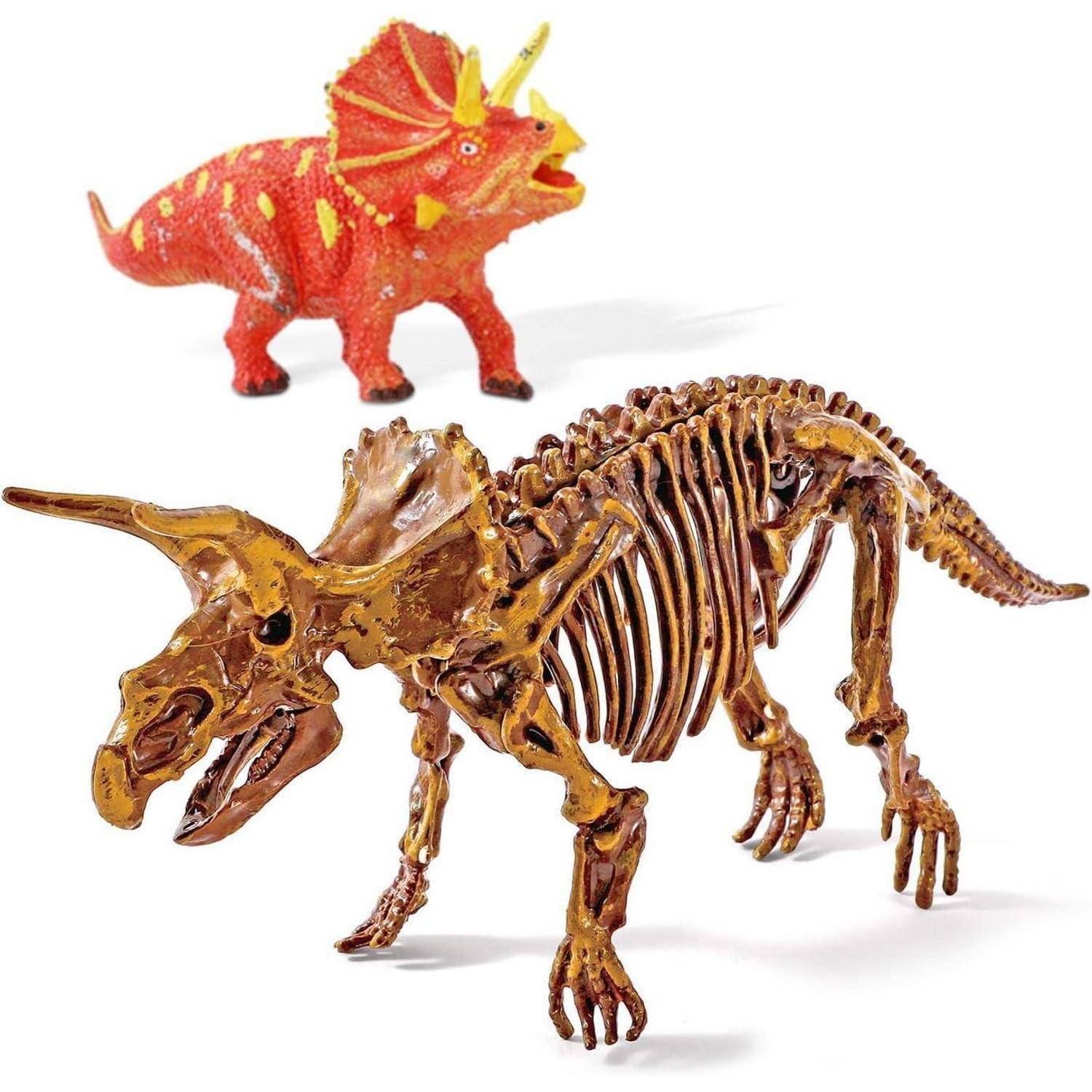 Zwei Triceratops-Figuren auf weißem Hintergrund: ein rotes Spielzeug hinten und ein goldenes Skelettmodell vorne.