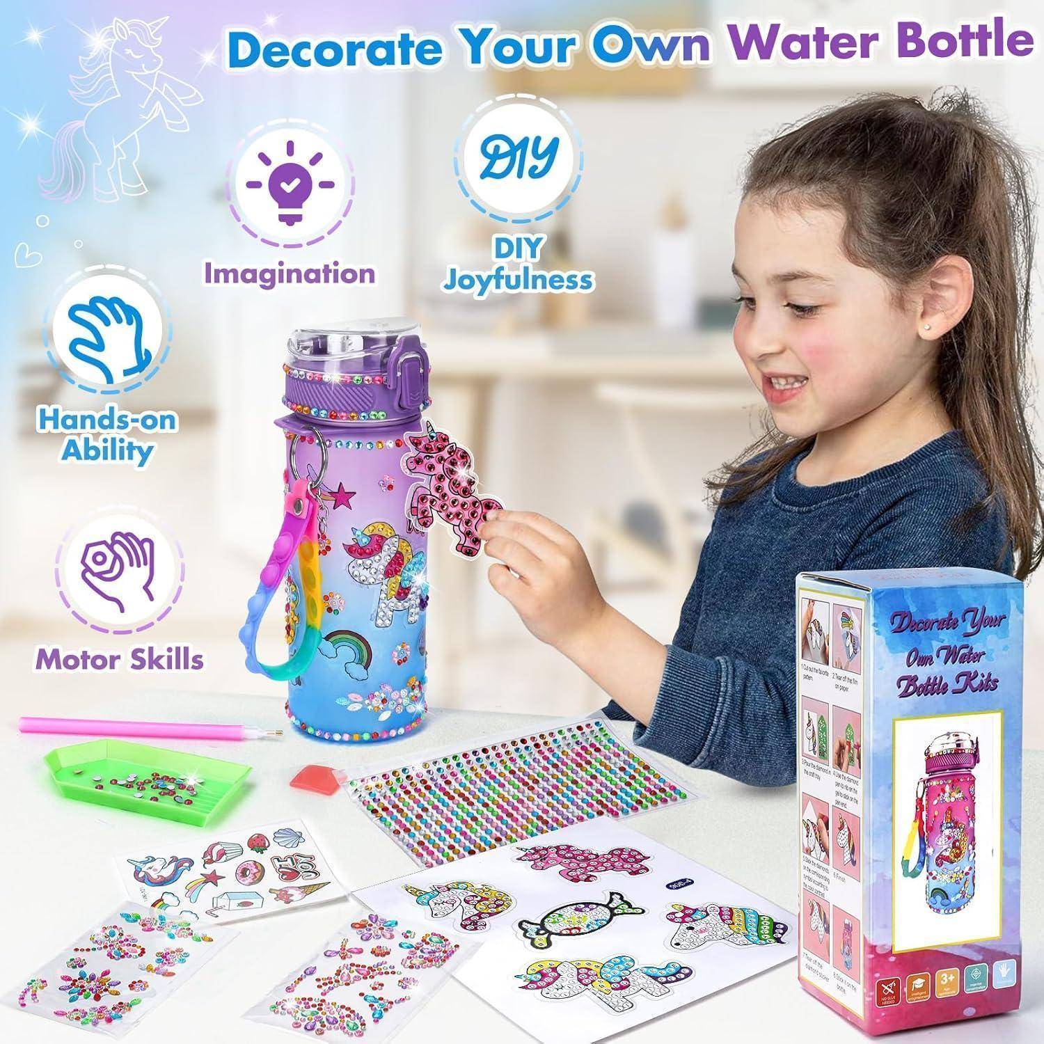 Mädchen, das eine violette Wasserflasche mit Aufklebern und Perlen aus einem DIY-Bastelset dekoriert, fördert praktisches, kreatives Spielen und motorische Fähigkeiten.