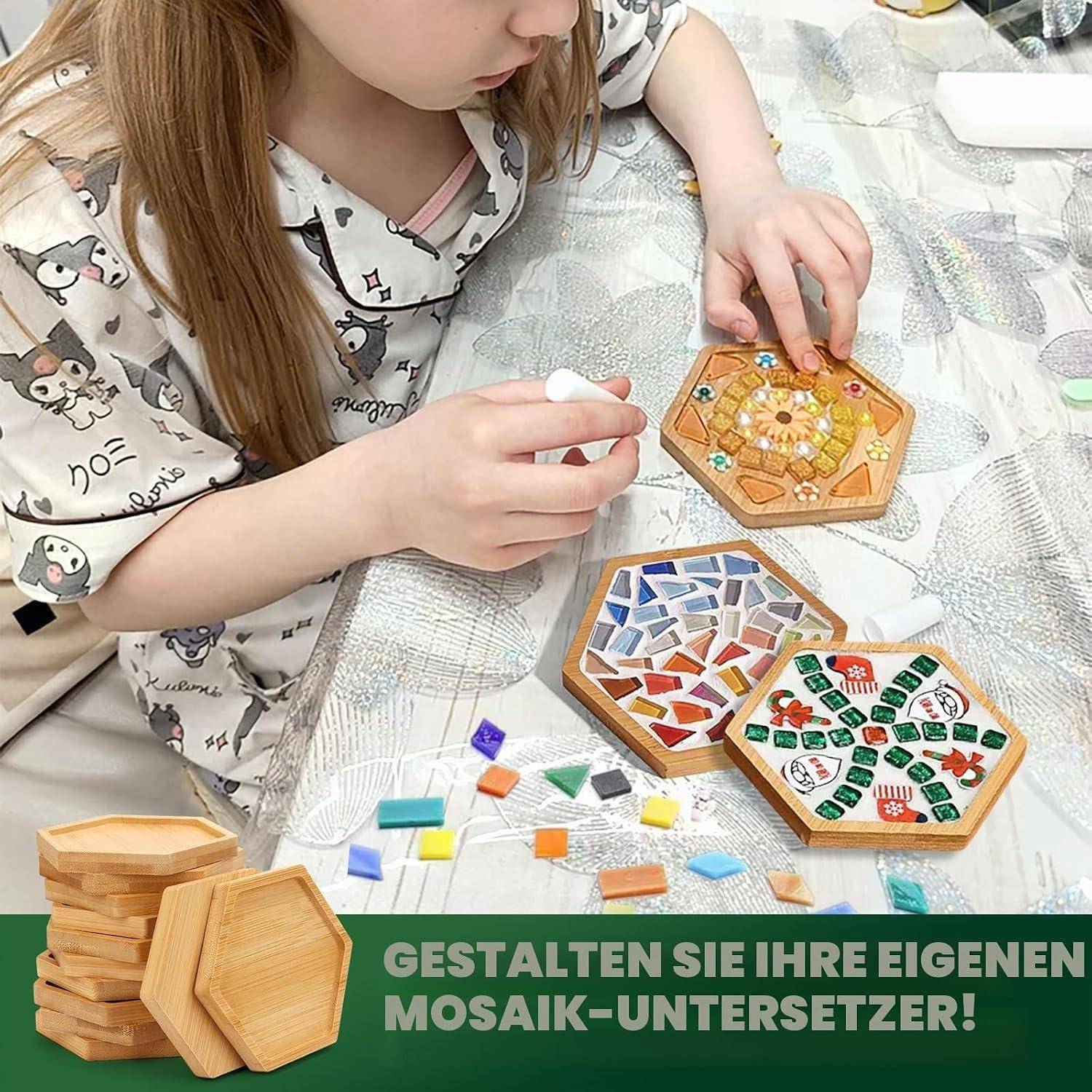 Kind gestaltet sechseckige Mosaik-Untersetzer mit bunten Kacheln; deutscher Text lautet „Gestalten Sie Ihre eigenen Mosaik-Untersetzer!