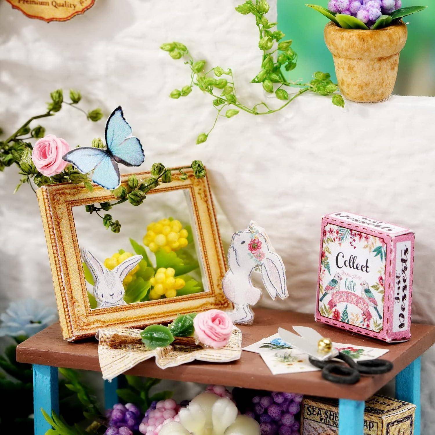 Miniatur-Handwerkausstellung auf einem Tisch: Blumenspiegel mit Papierhäschen und Schmetterling, kleine „Sammeln