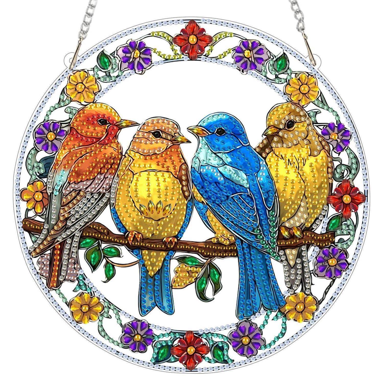 Dekoratives kreisförmiges Hängeornament mit vier bunten Vögeln, die auf einem Ast sitzen, umgeben von einem Blumenkranzdesign.