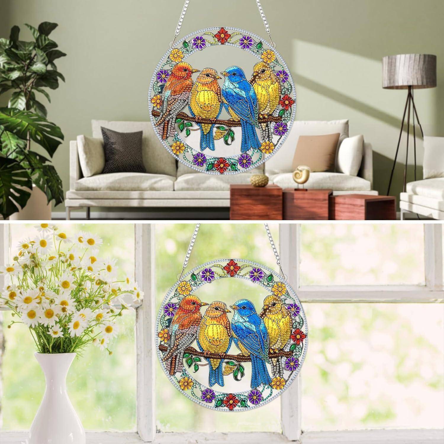 Rundes Buntglaskunst-Fensterbild zum Aufhängen mit vier farbenfrohen Vögeln auf einem Blütenkranz, dargestellt in einem Wohnzimmer und an einem Fenster.