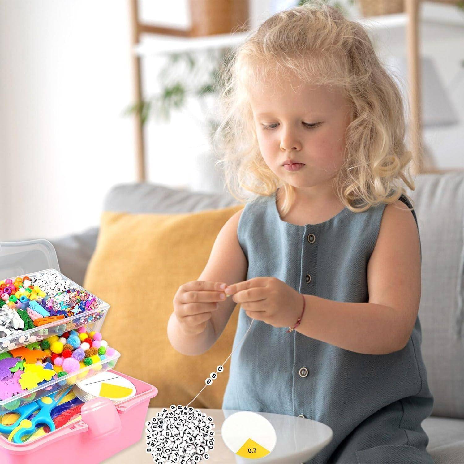 Ein junges Mädchen sitzt an einem Tisch und fädelt kleine Perlen auf, während es mit bunten Materialien bastelt, die in Kunststoffboxen neben ihr auf einem Sofa angeordnet sind.